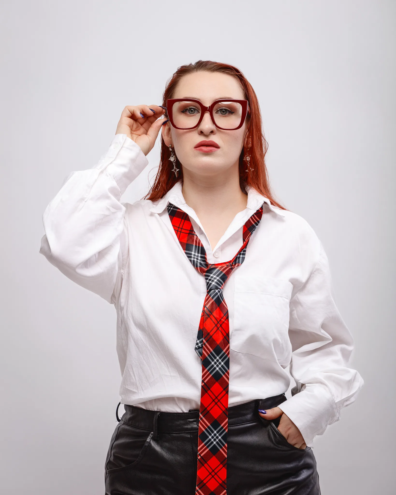 Woman wearing glasses, white shirt, red tie.