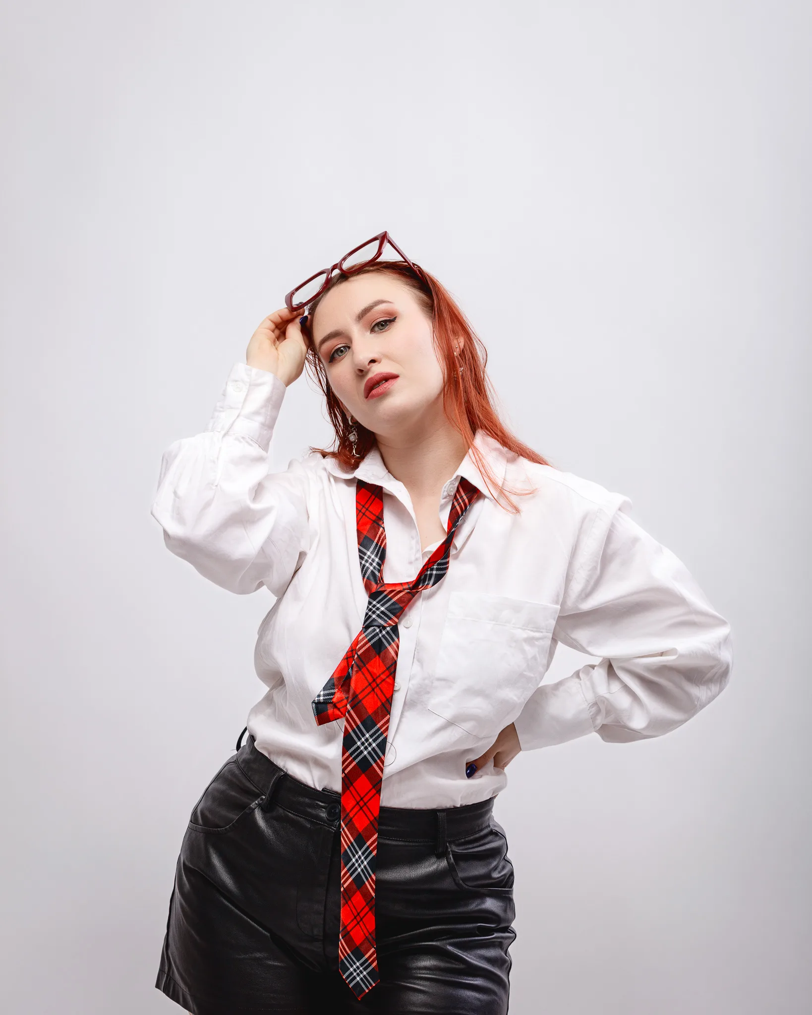 Person wearing a white shirt and red checkered tie.