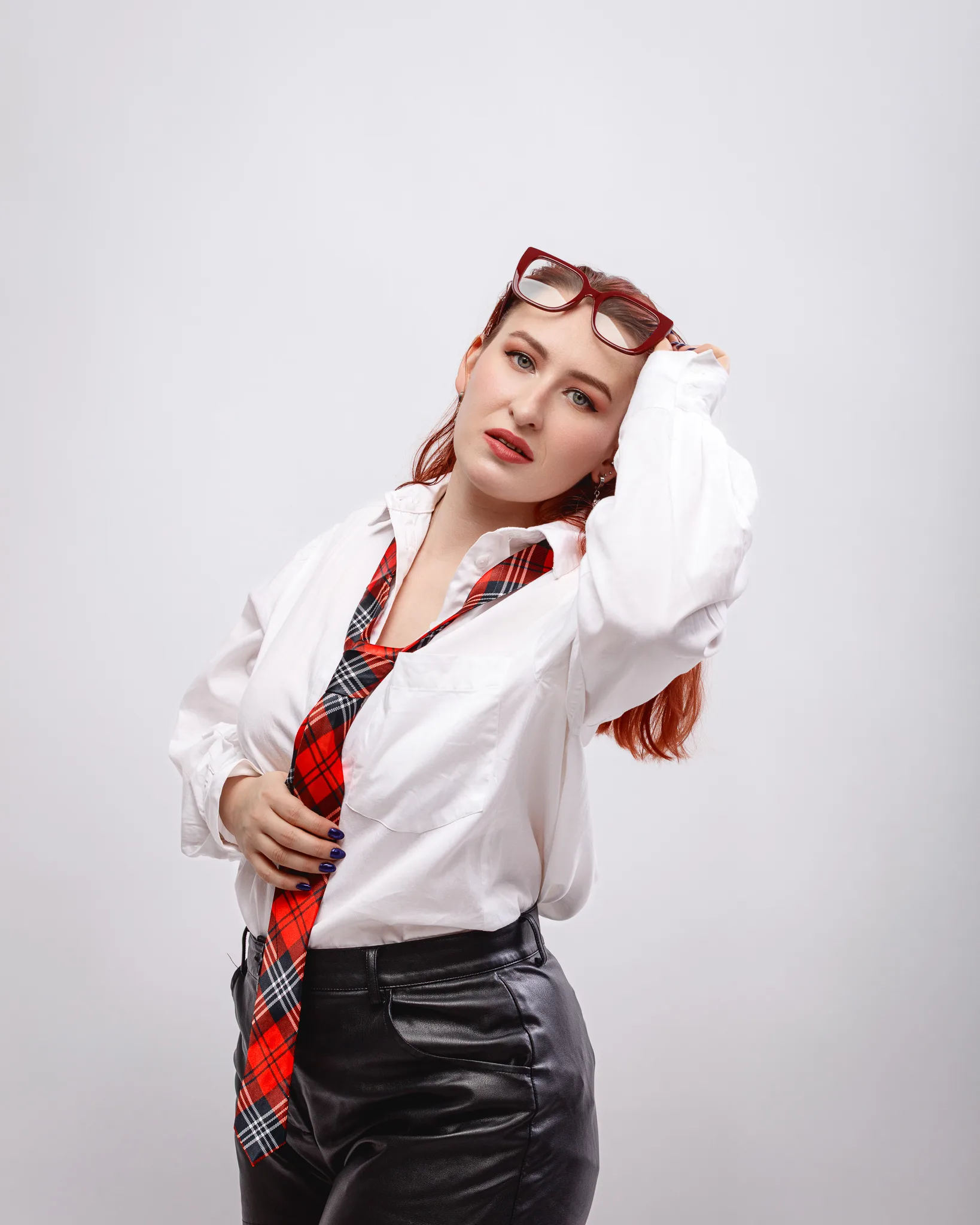 Person in white shirt with tartan tie posing.