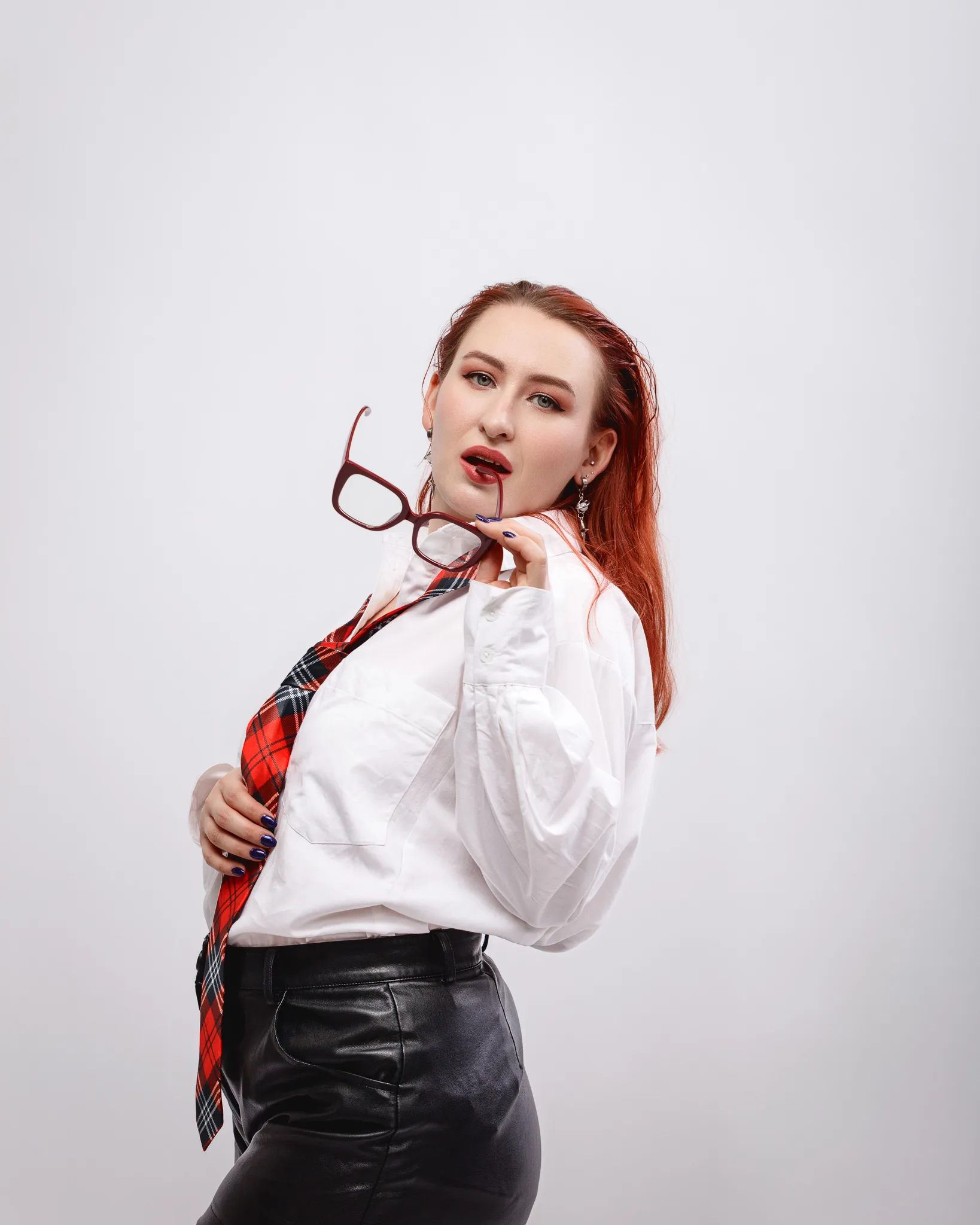 Fashionable woman holding glasses in stylish outfit.