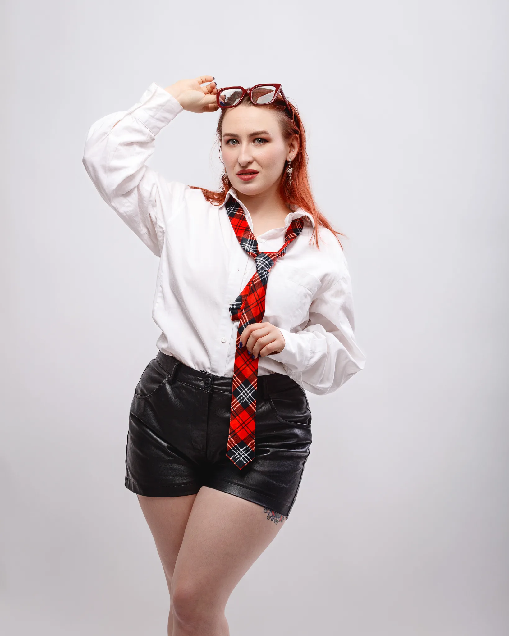 Person in stylish outfit with glasses and tie.