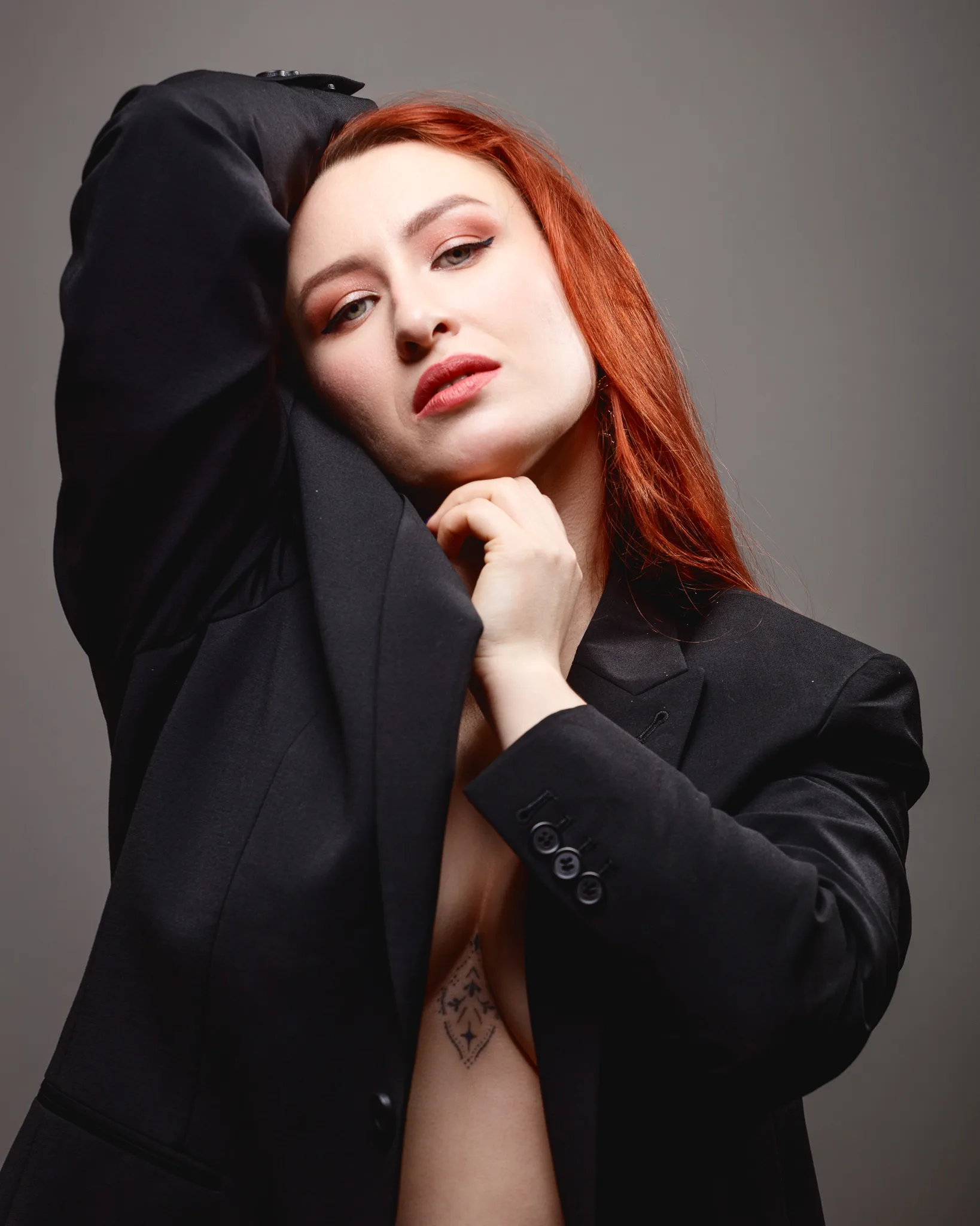 Person with red hair in a black suit.