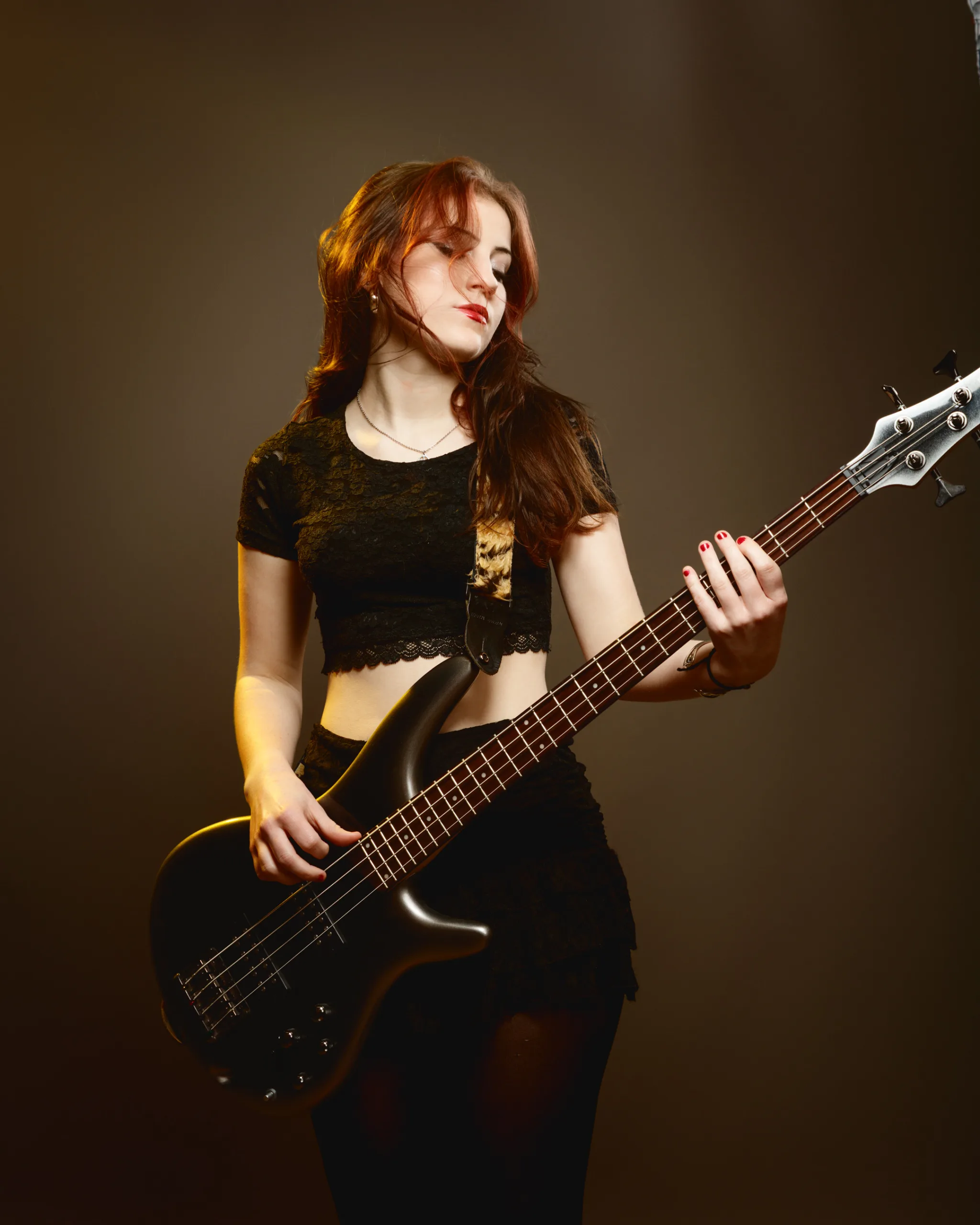 Woman playing an electric bass guitar.