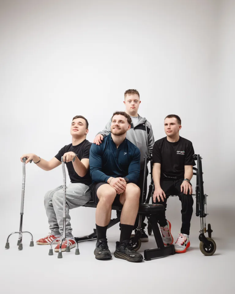 Four young men posing in studio setting