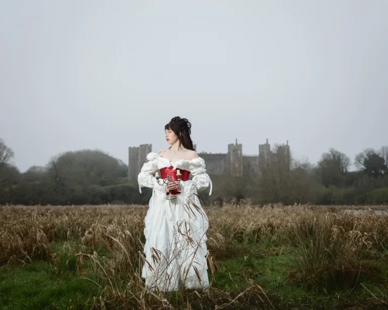 Woman in white dress near a castle