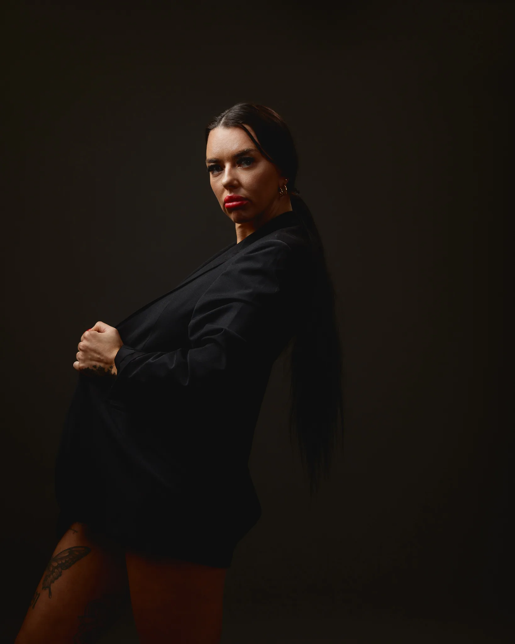 Woman in dark clothing posing confidently