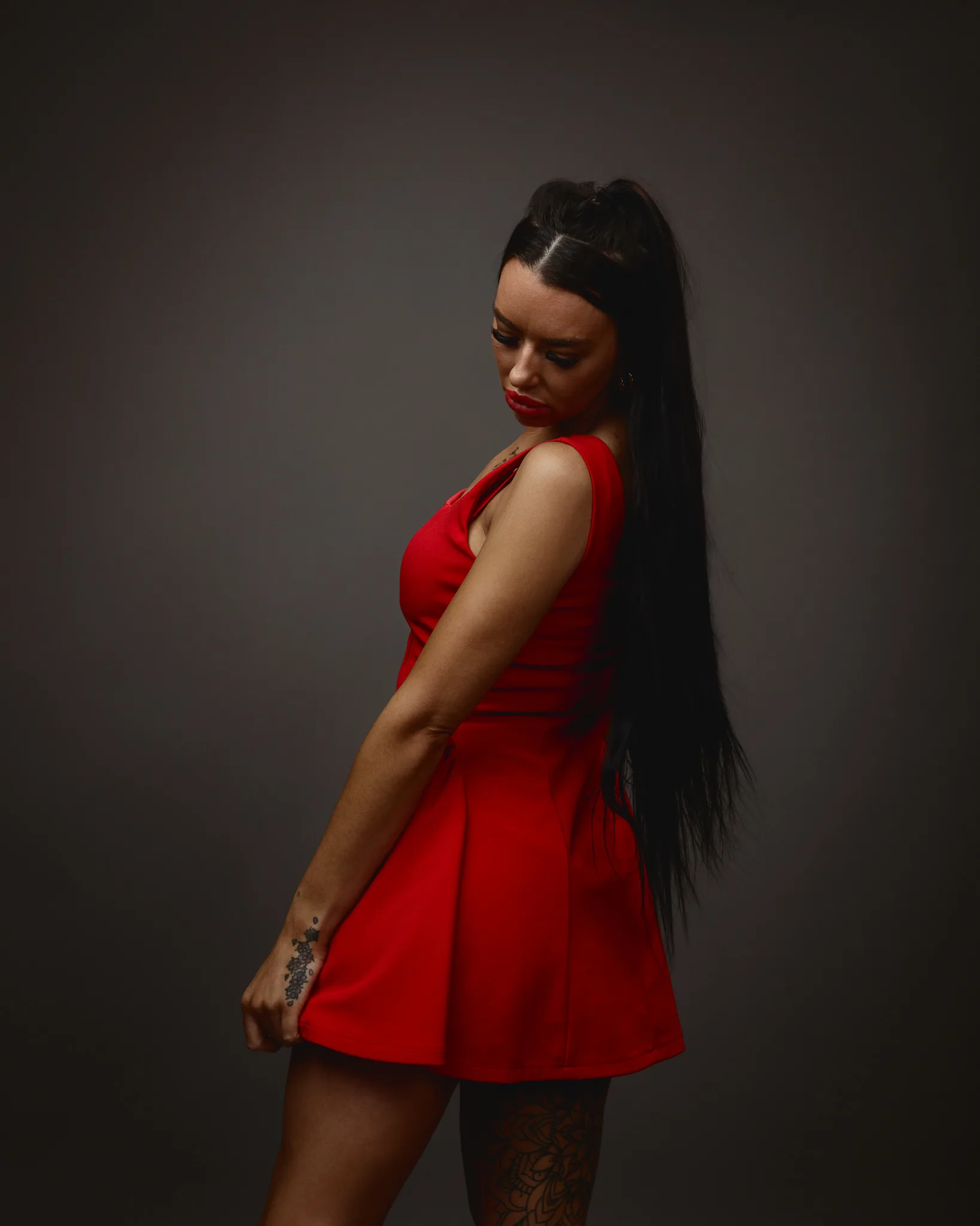 Woman in red dress with tattoos.