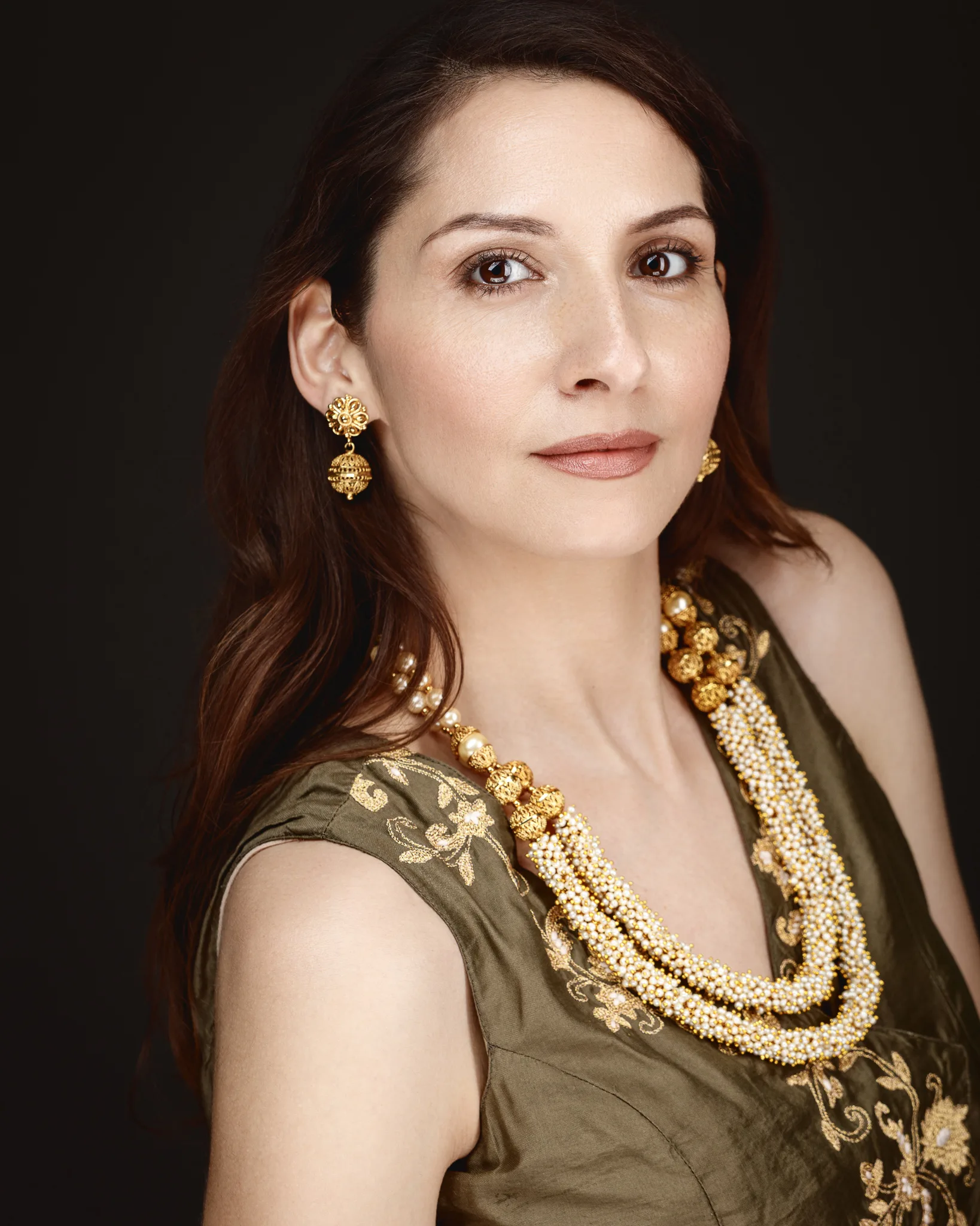 Woman wearing gold jewellery and embroidered dress