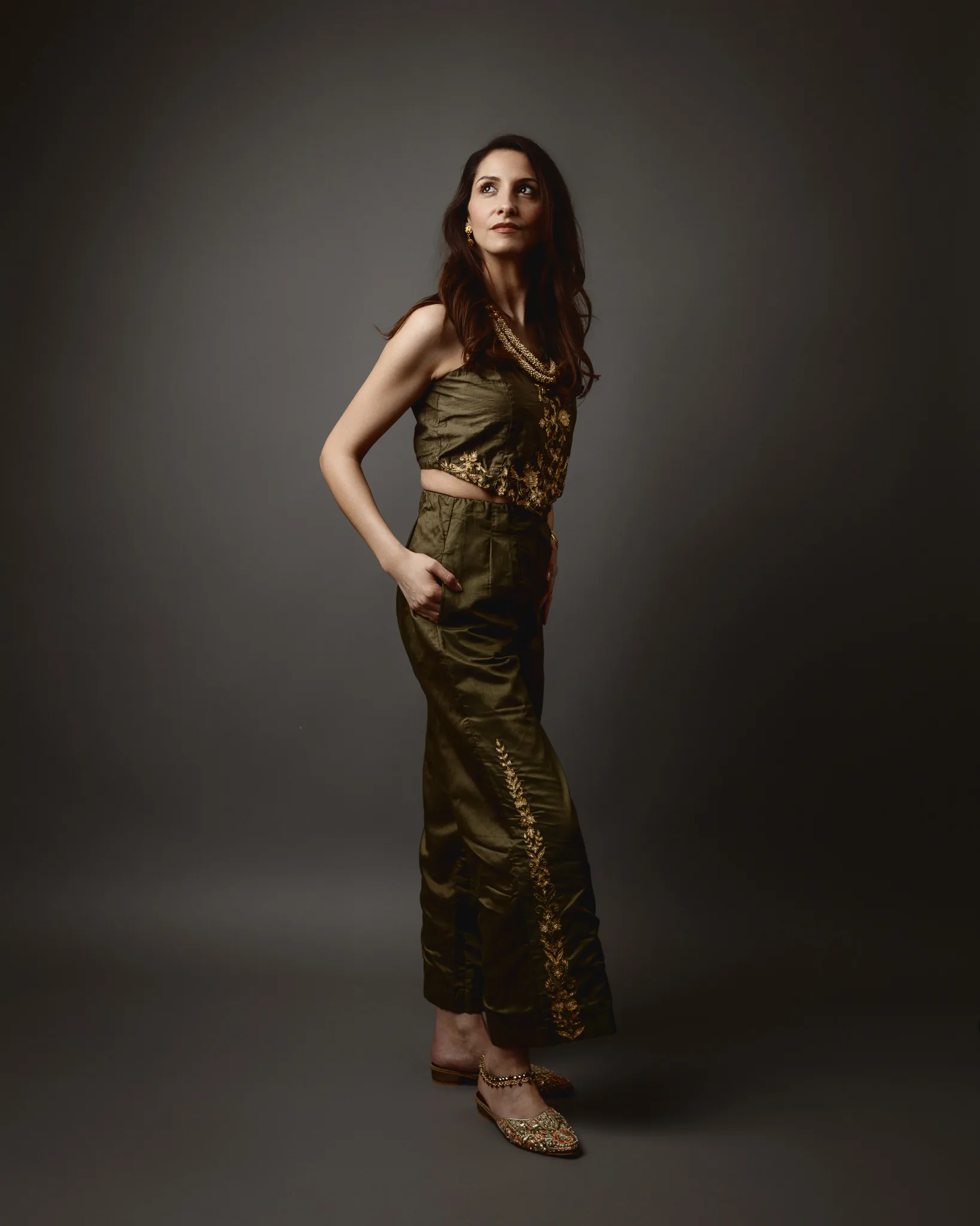 Woman in elegant green attire poses confidently