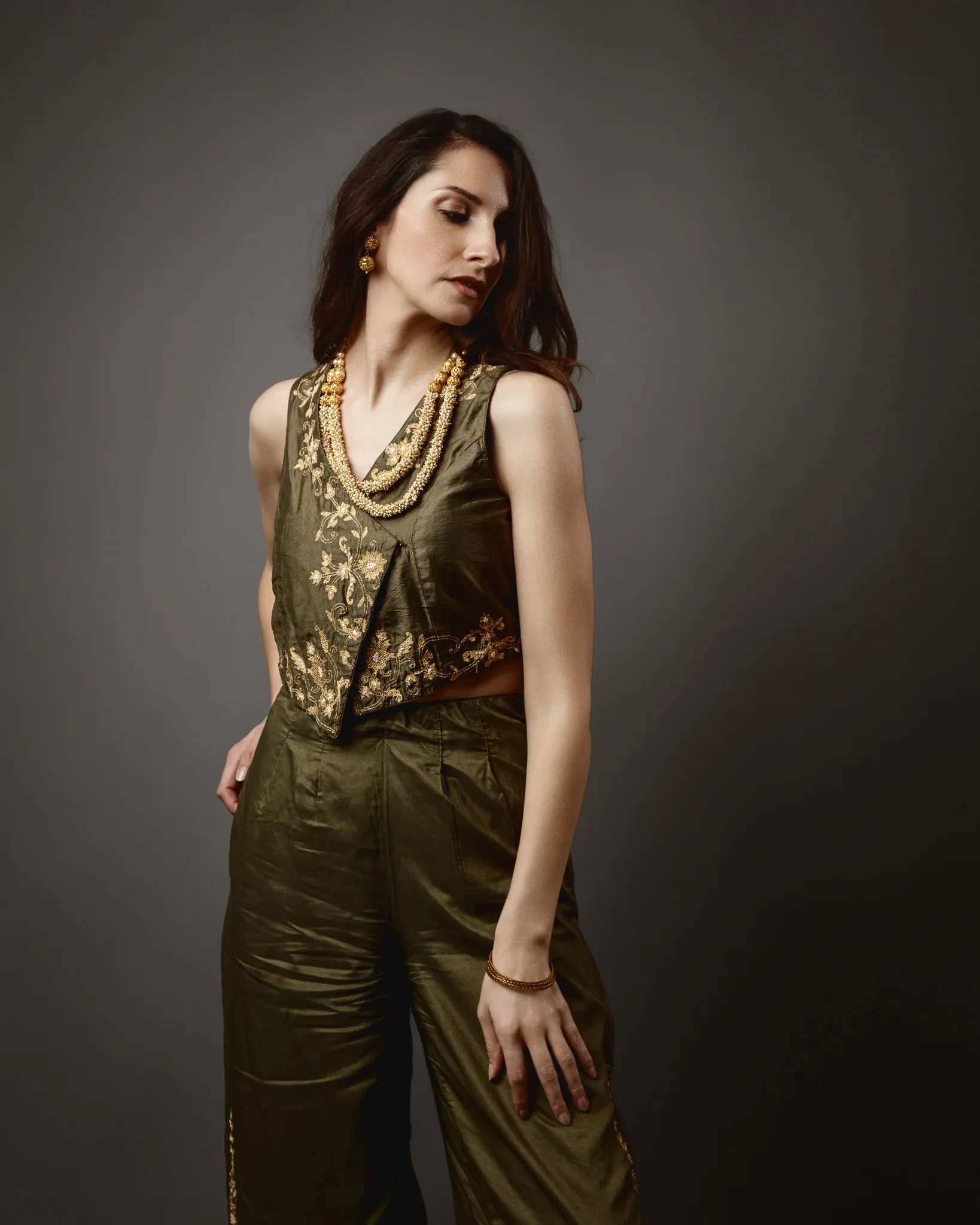 Woman in elegant attire with gold jewelry