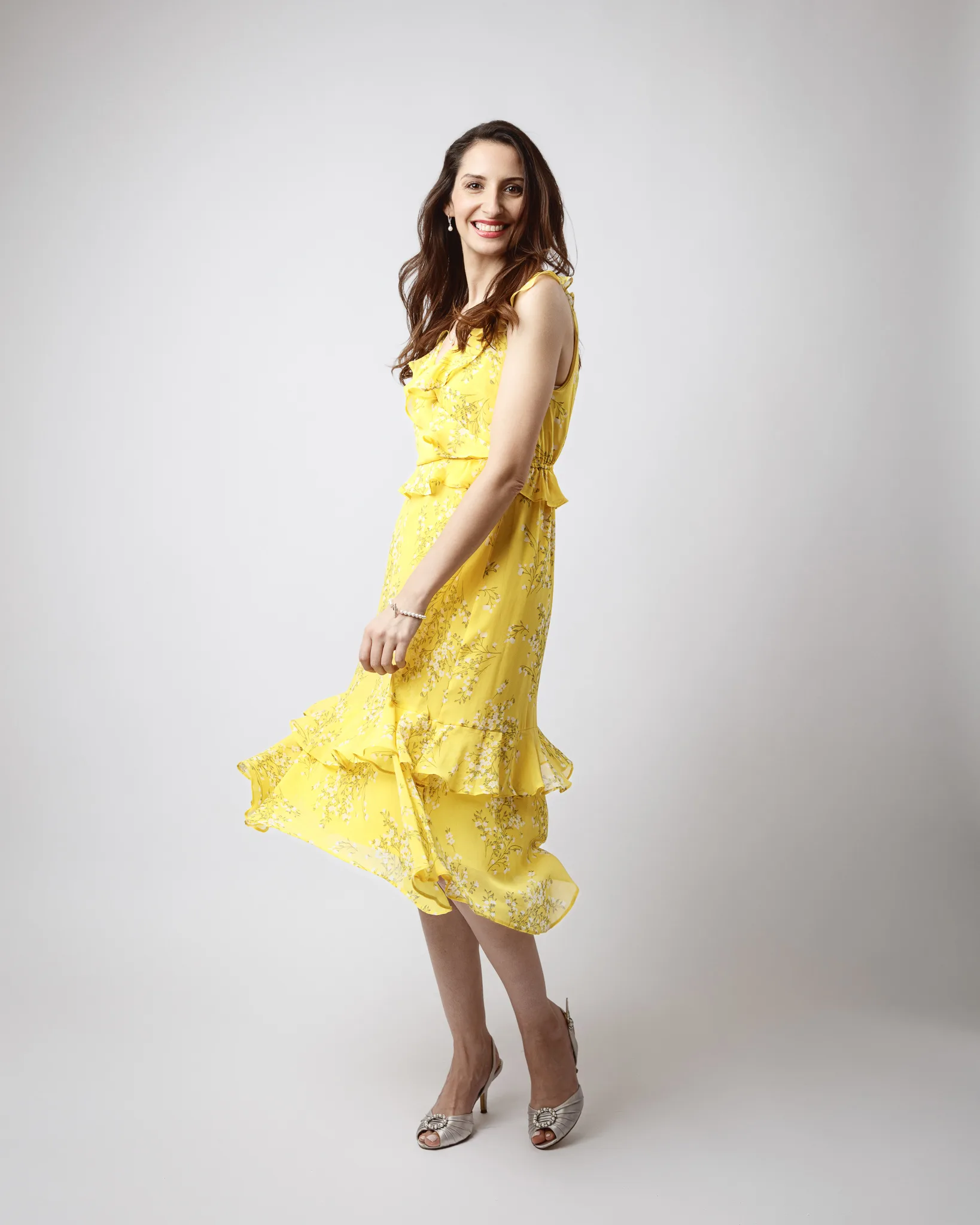 Woman in yellow floral dress smiling