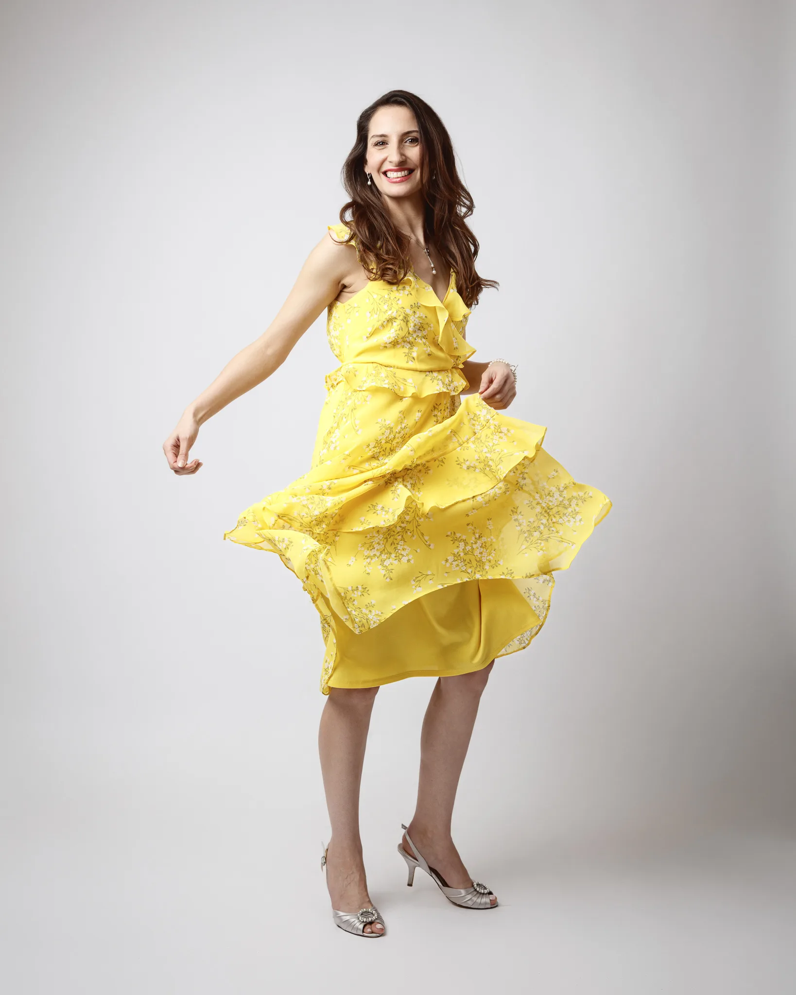 Woman in yellow dress smiling and twirling