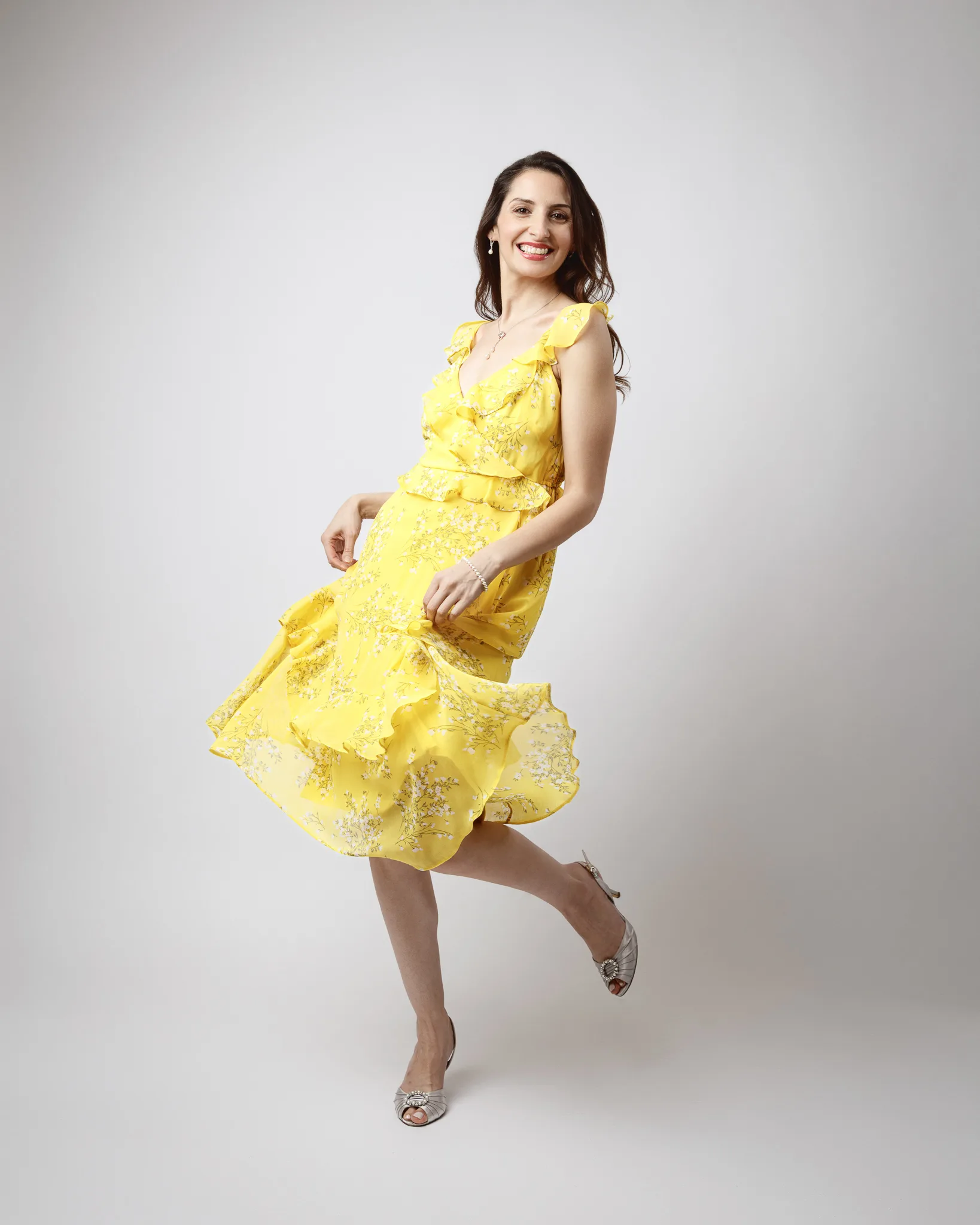 Woman in yellow dress twirling with smile