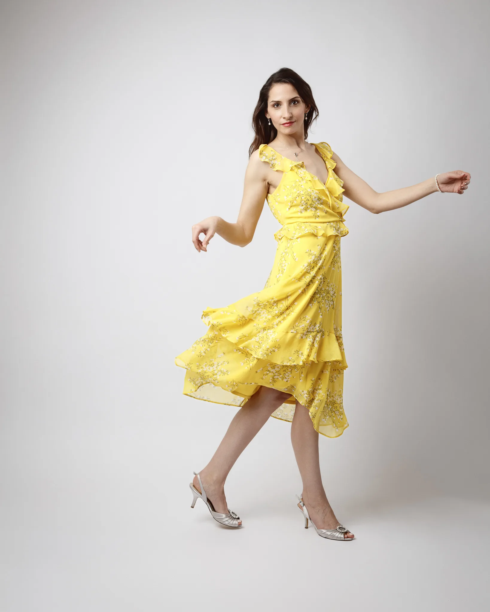 Woman in yellow floral dress posing