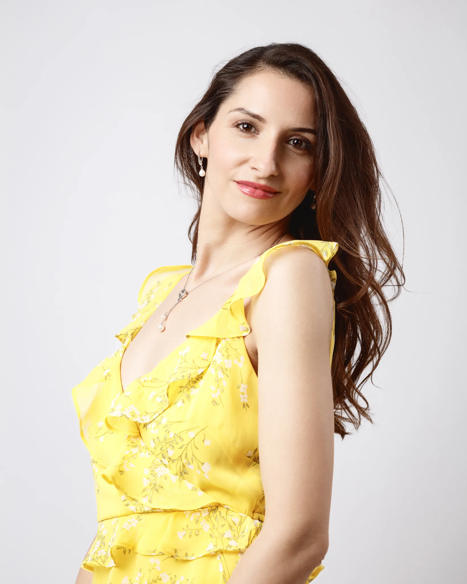 Woman in yellow floral dress smiling