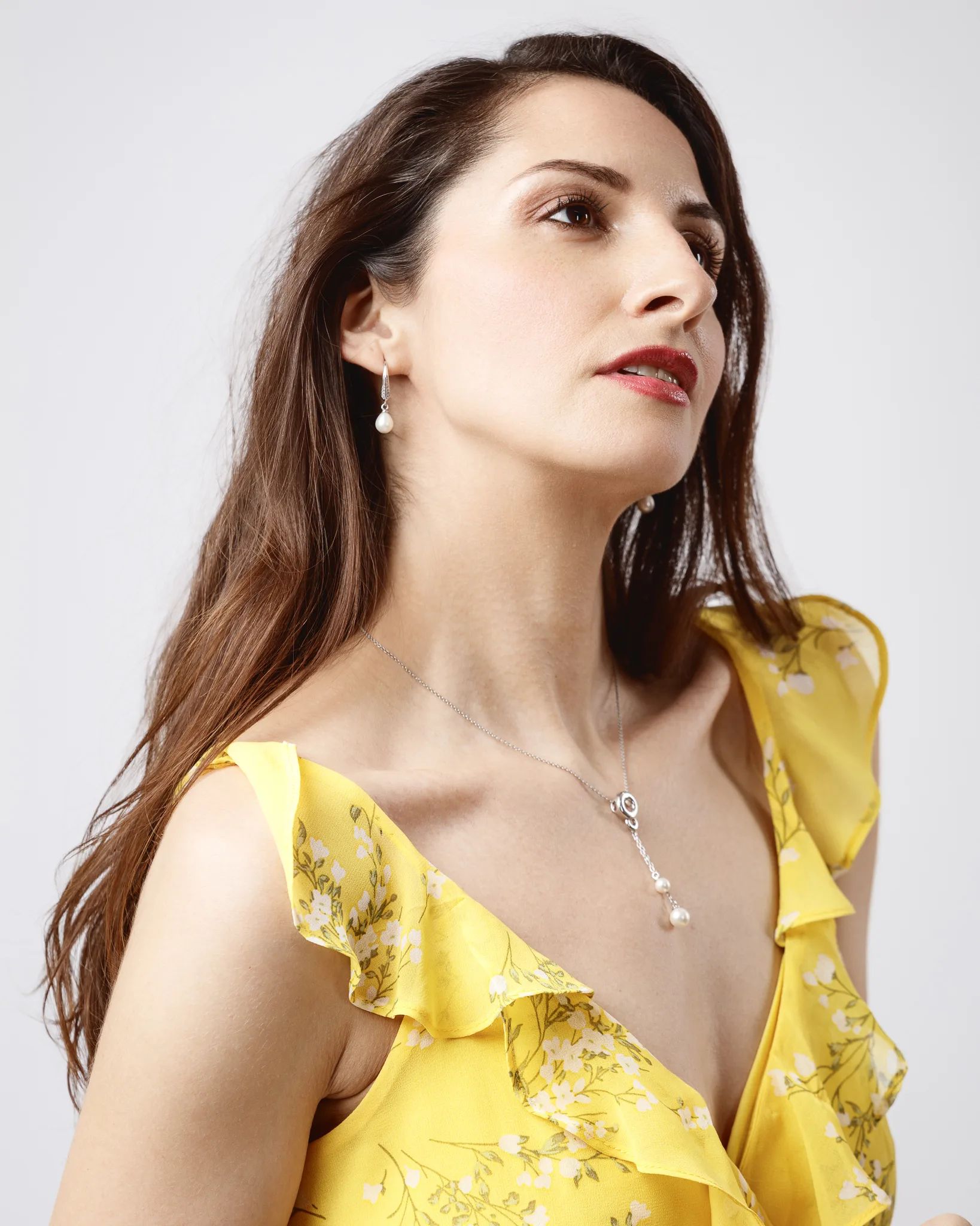 Woman in yellow floral dress looking up