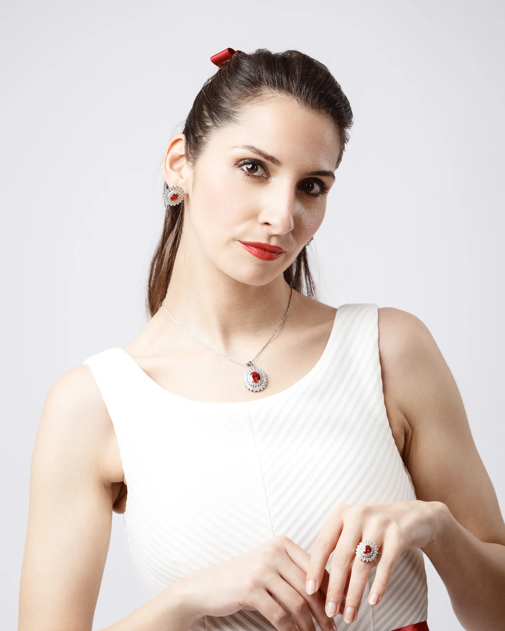 Woman wearing red jewellery and white dress