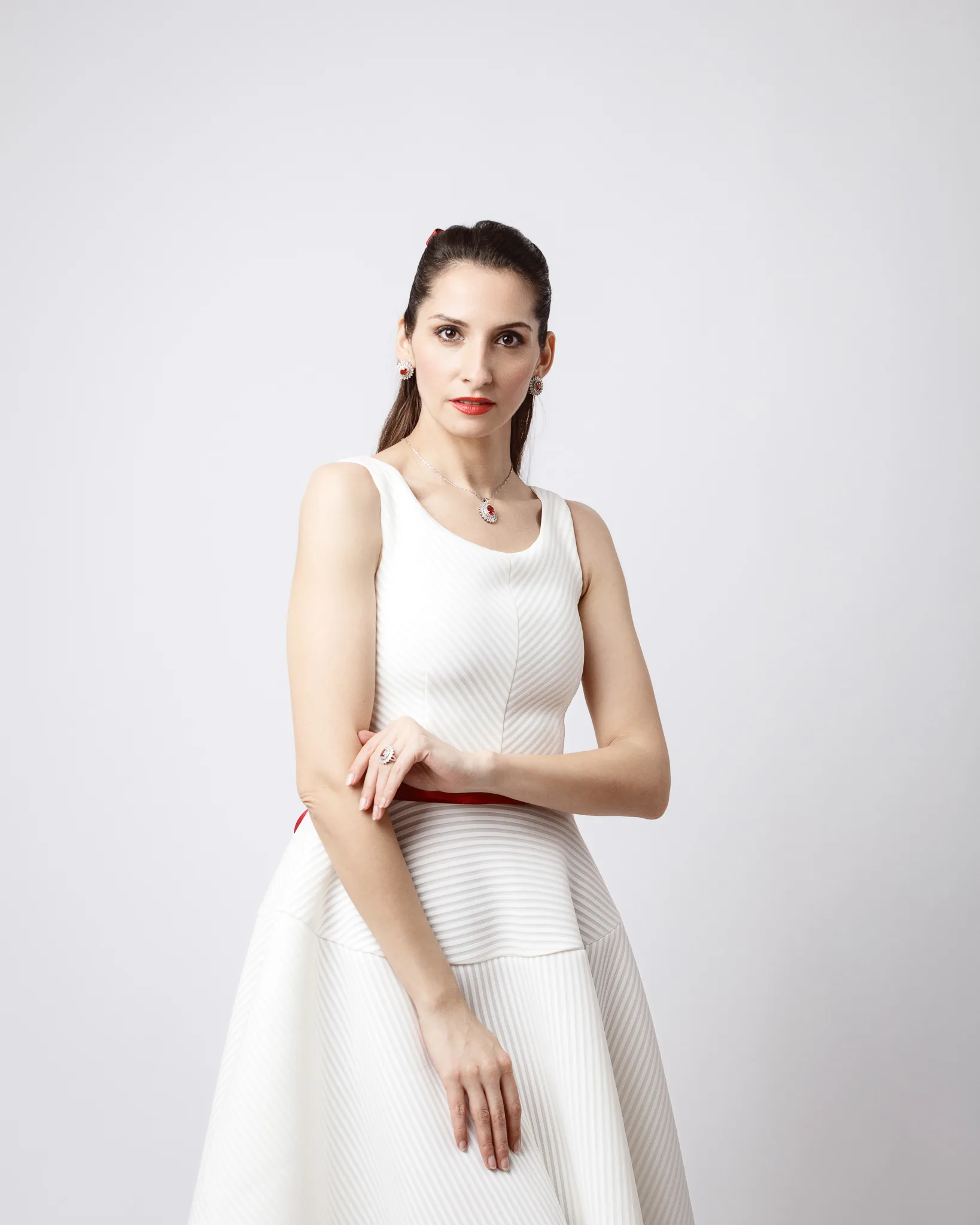 Woman in elegant white dress posing.
