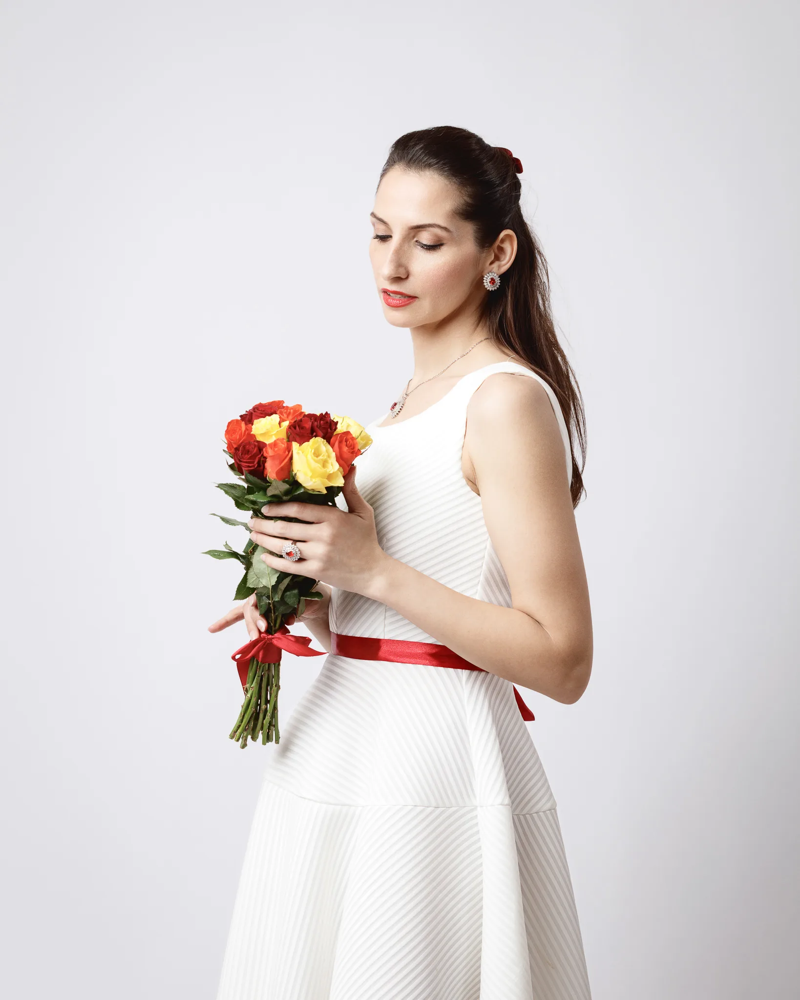 Woman holding bouquet of red and yellow roses