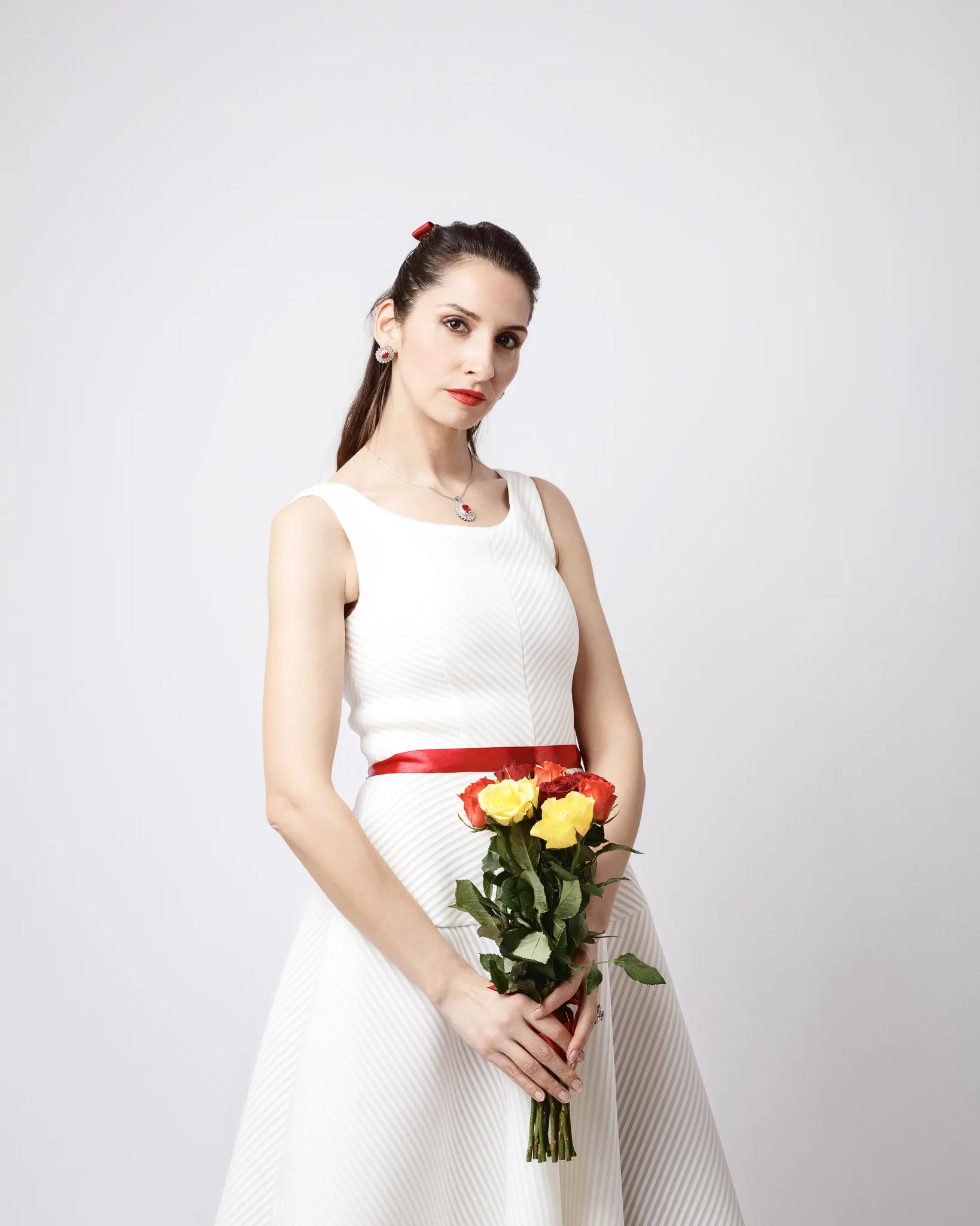 Woman in white dress holding roses