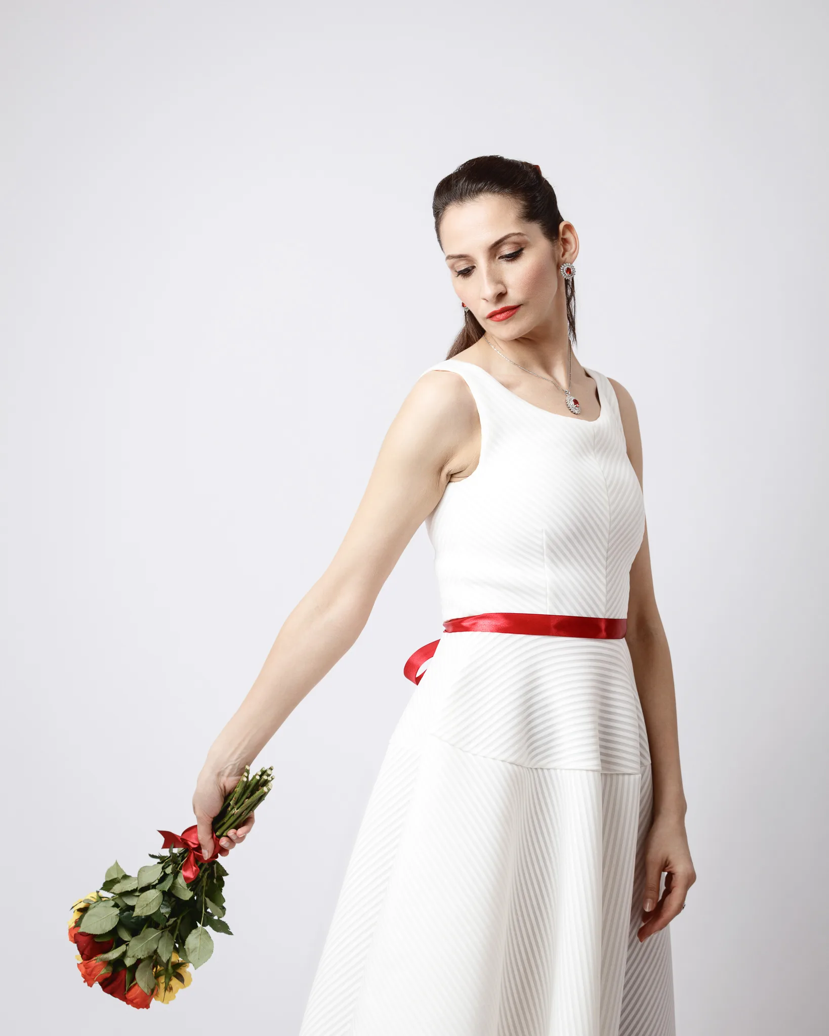 Woman in white dress holding roses