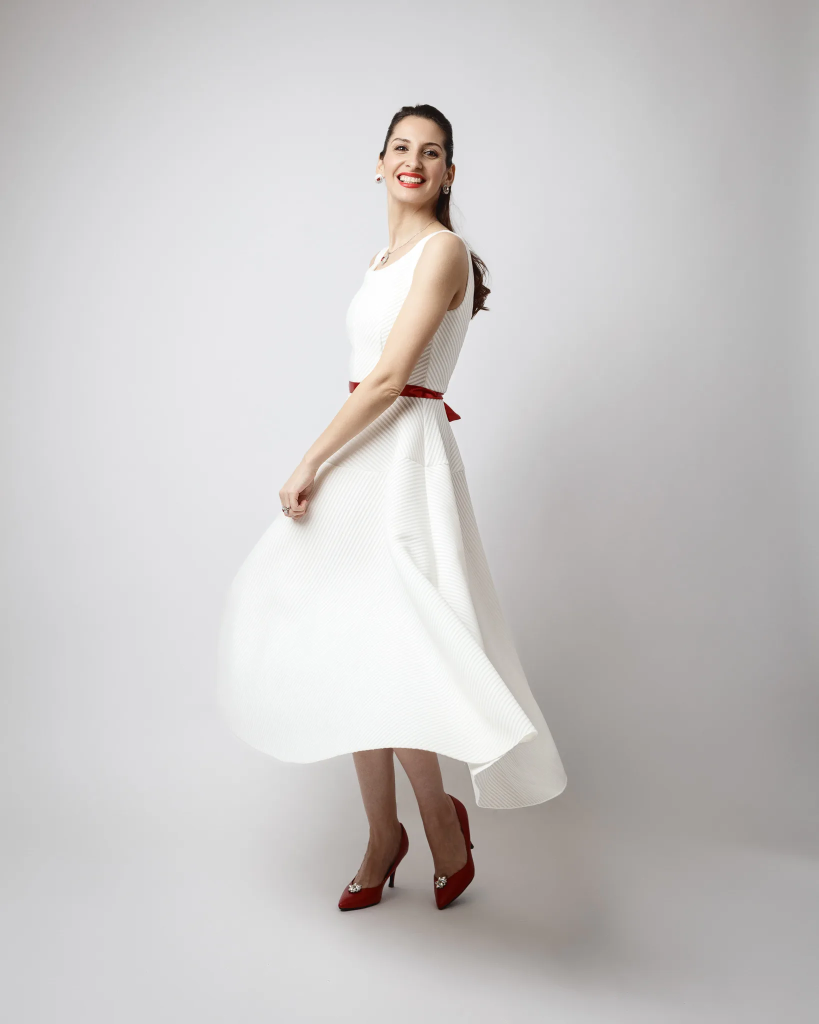 Woman in white dress spins joyfully.