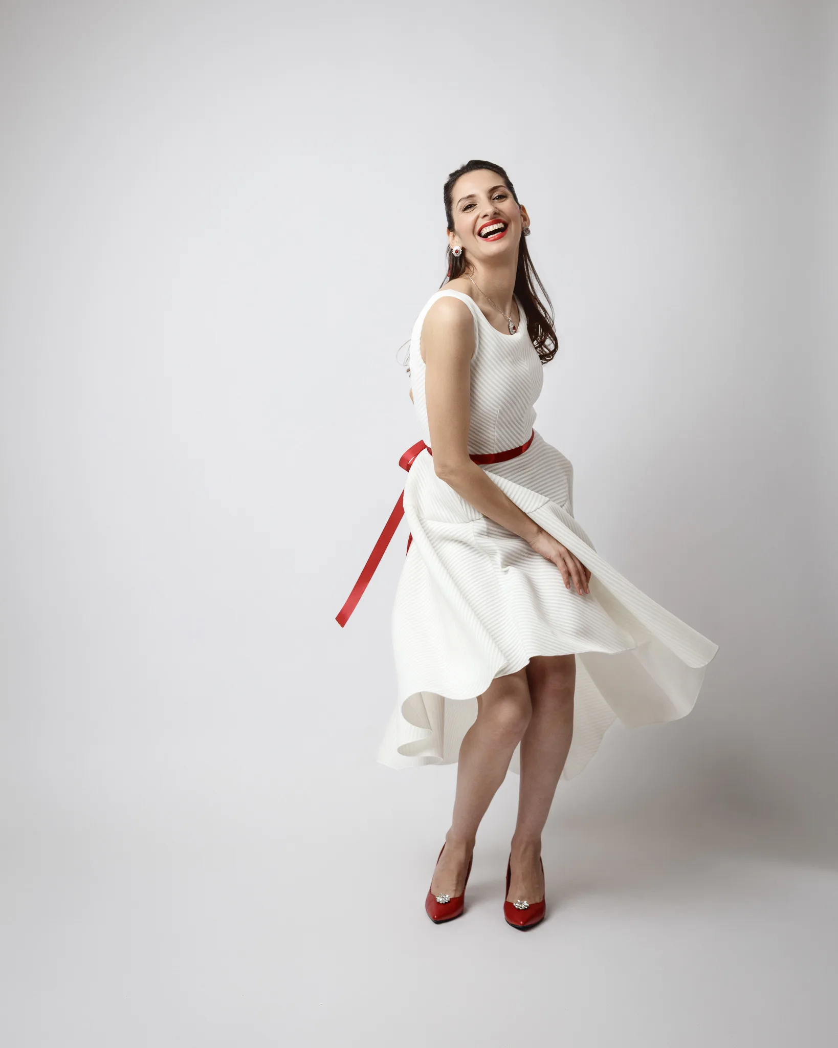 Smiling woman in white dress with red accents