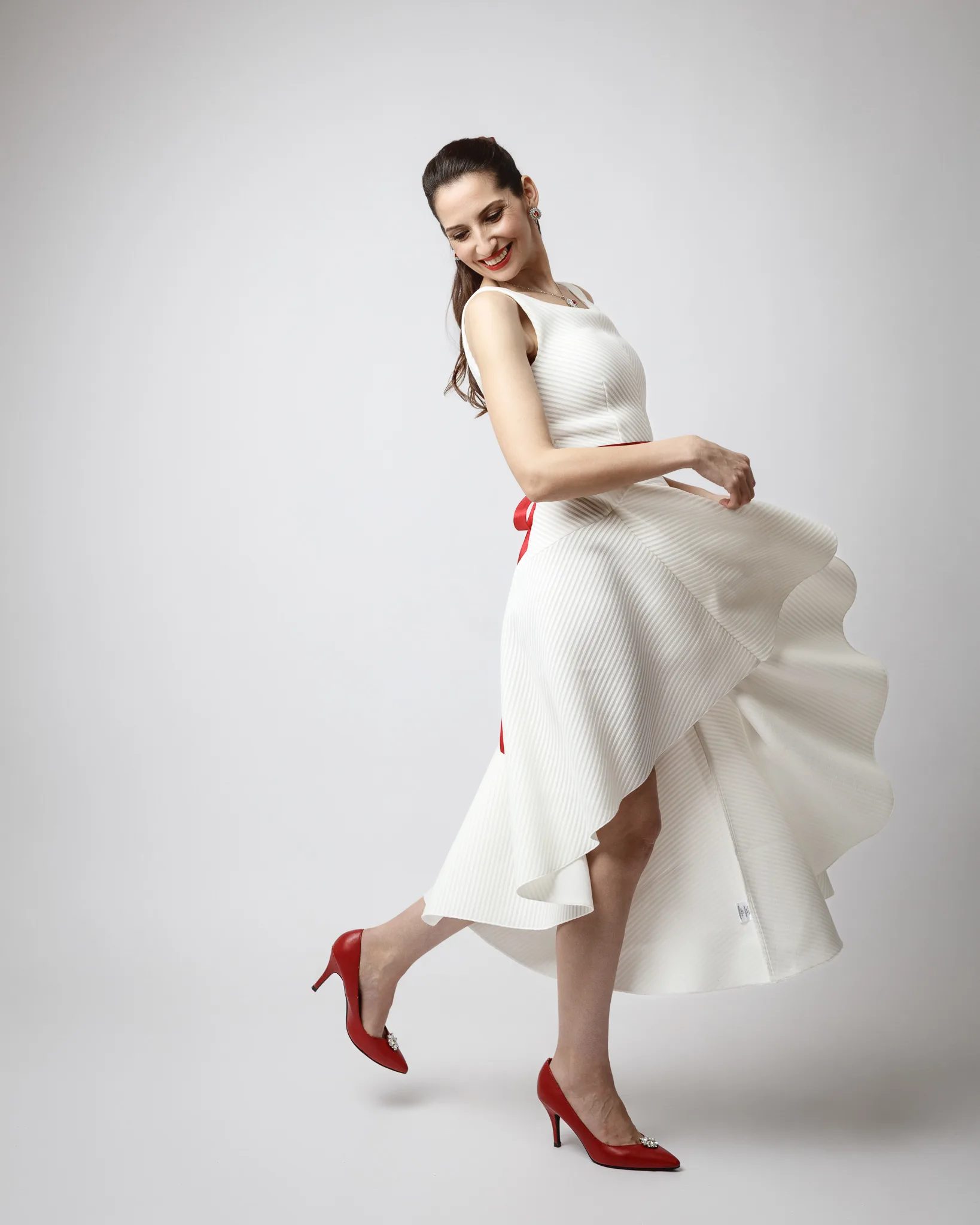 Smiling woman twirling in a white dress