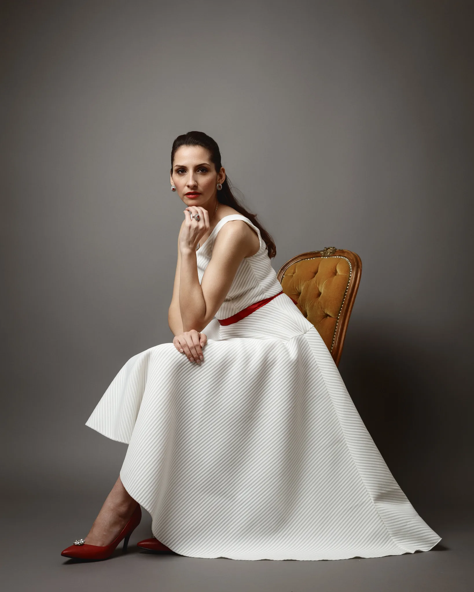 Woman in white dress sitting gracefully.