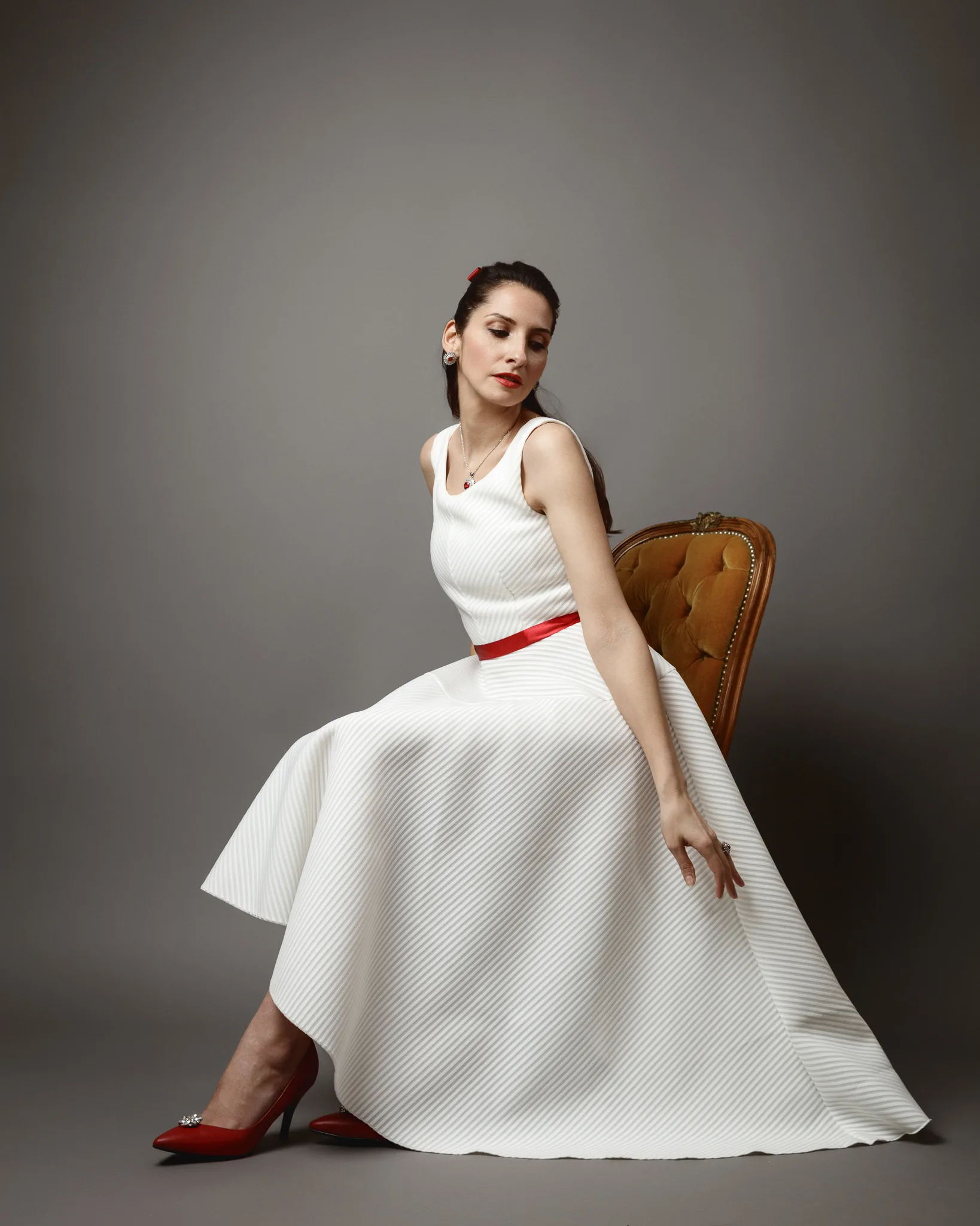 Elegant woman in white dress on chair