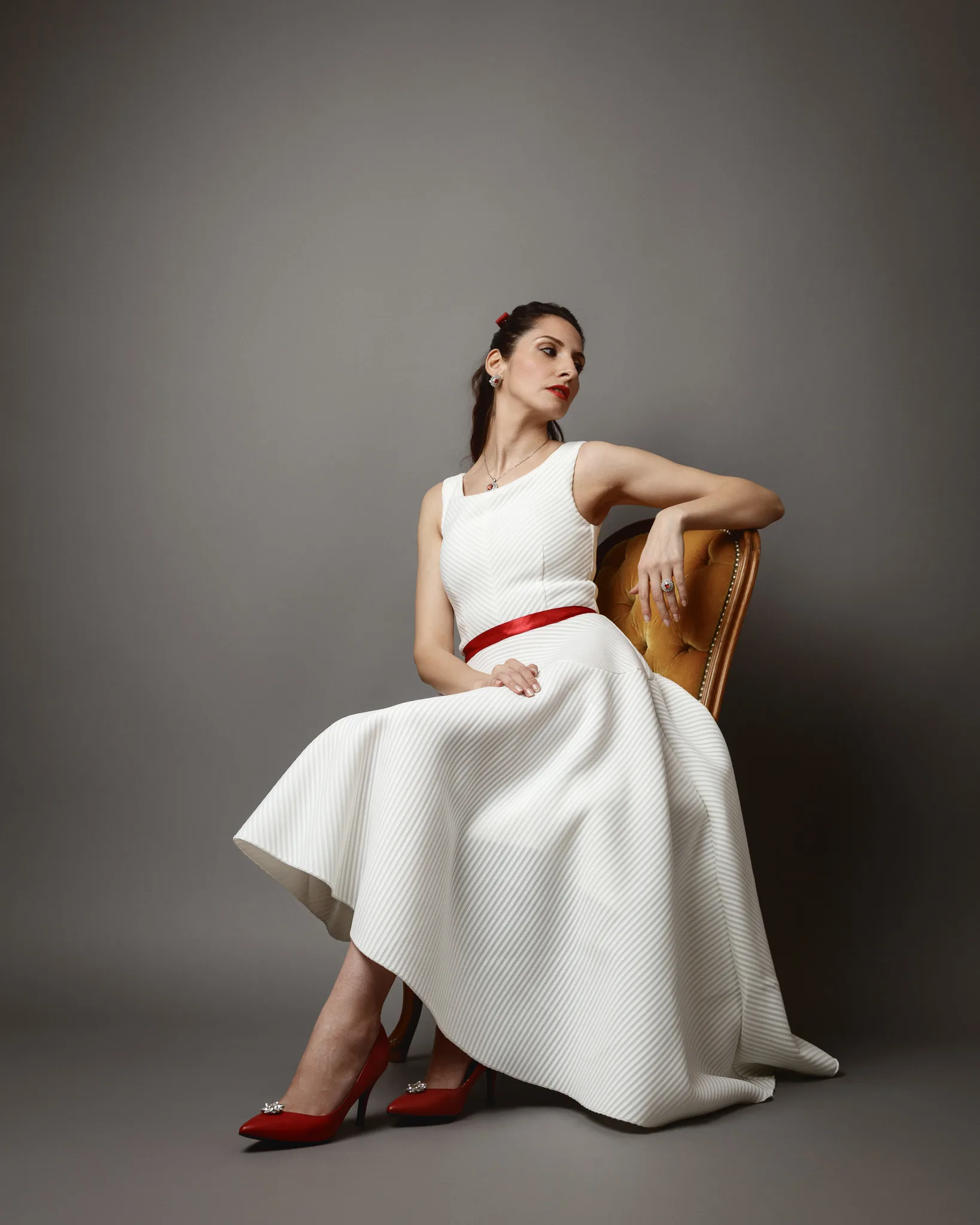 Elegant woman in white dress seated gracefully