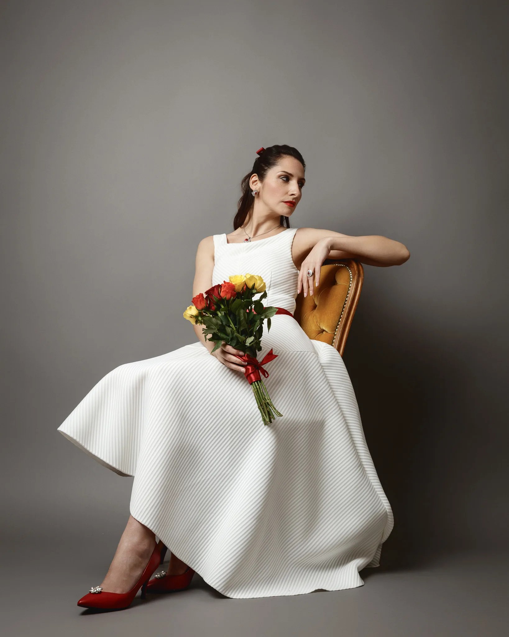Elegant woman in white dress holding flowers