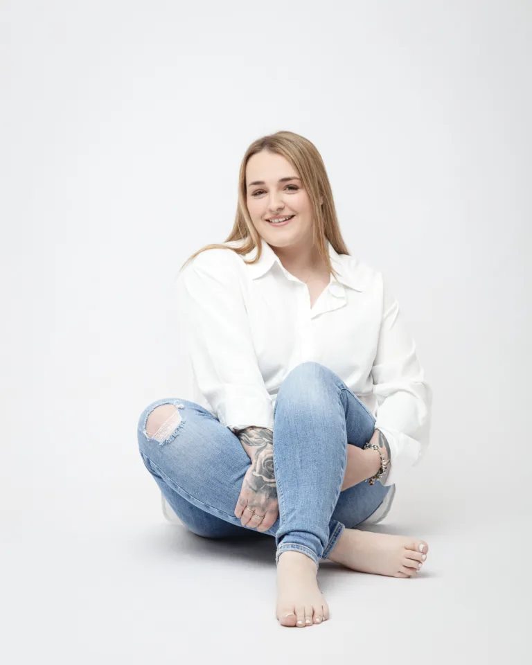 Woman in casual attire sitting on floor