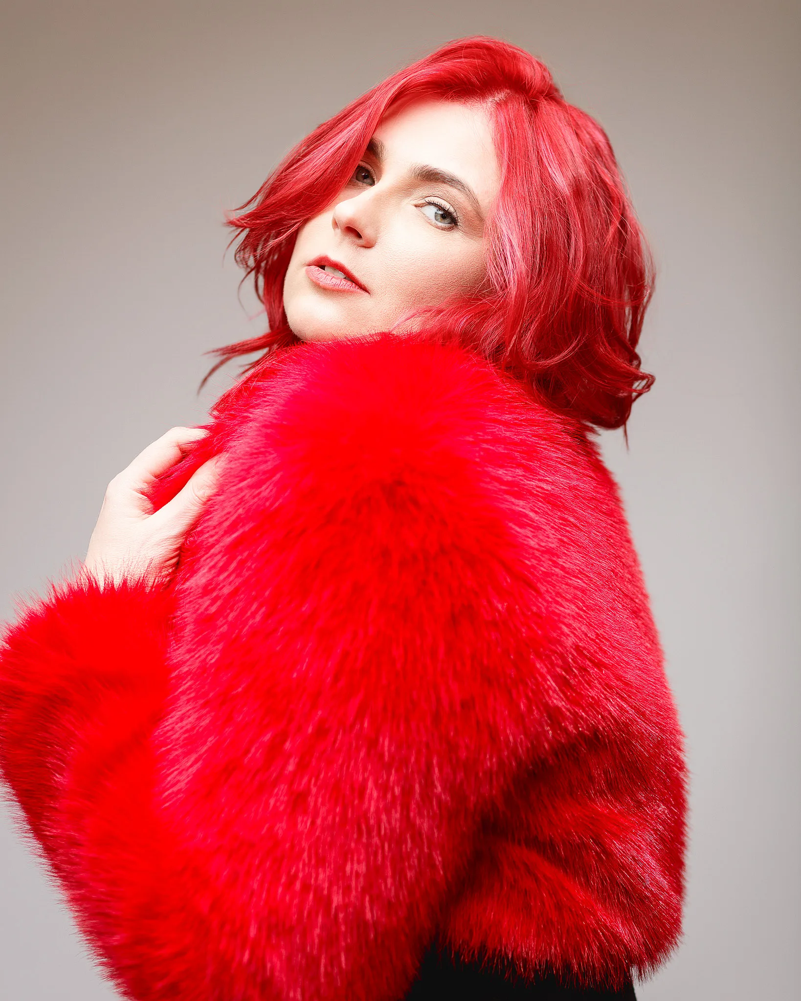 Person wearing vibrant red fur coat.