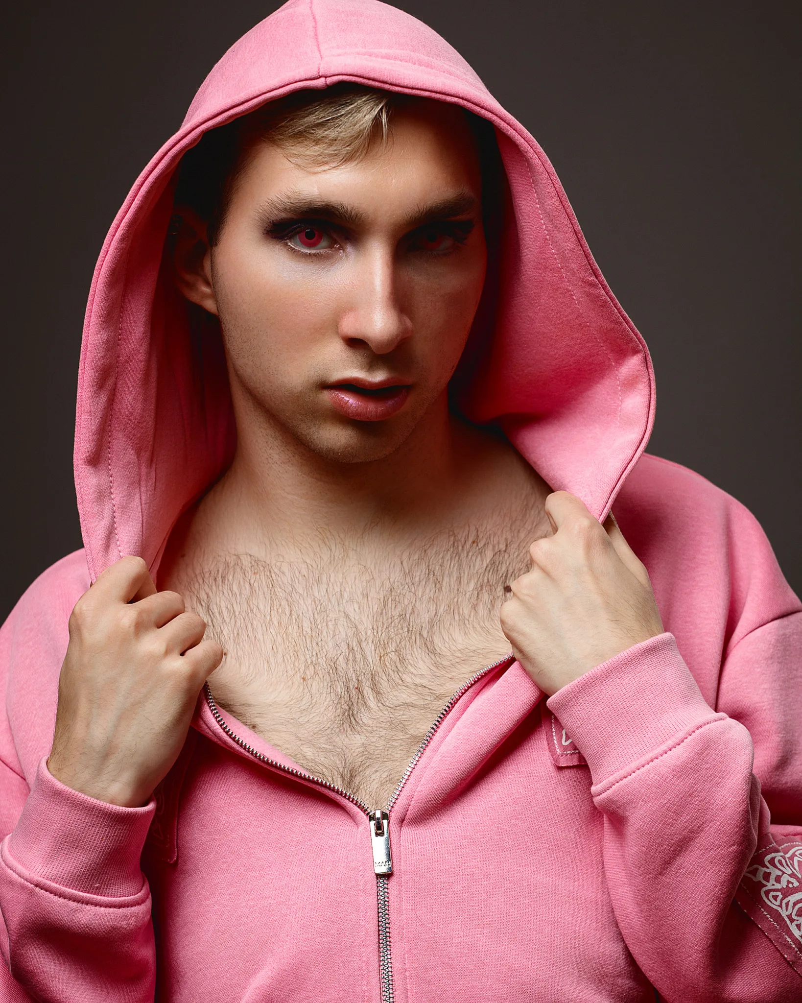 Person posing in pink hoodie