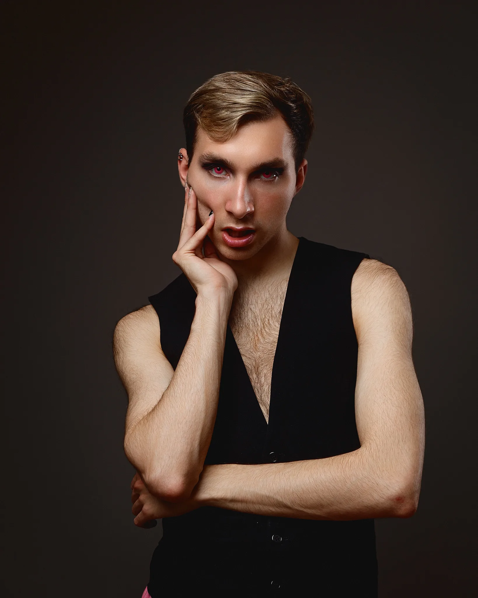 Person posing with dramatic makeup and vest