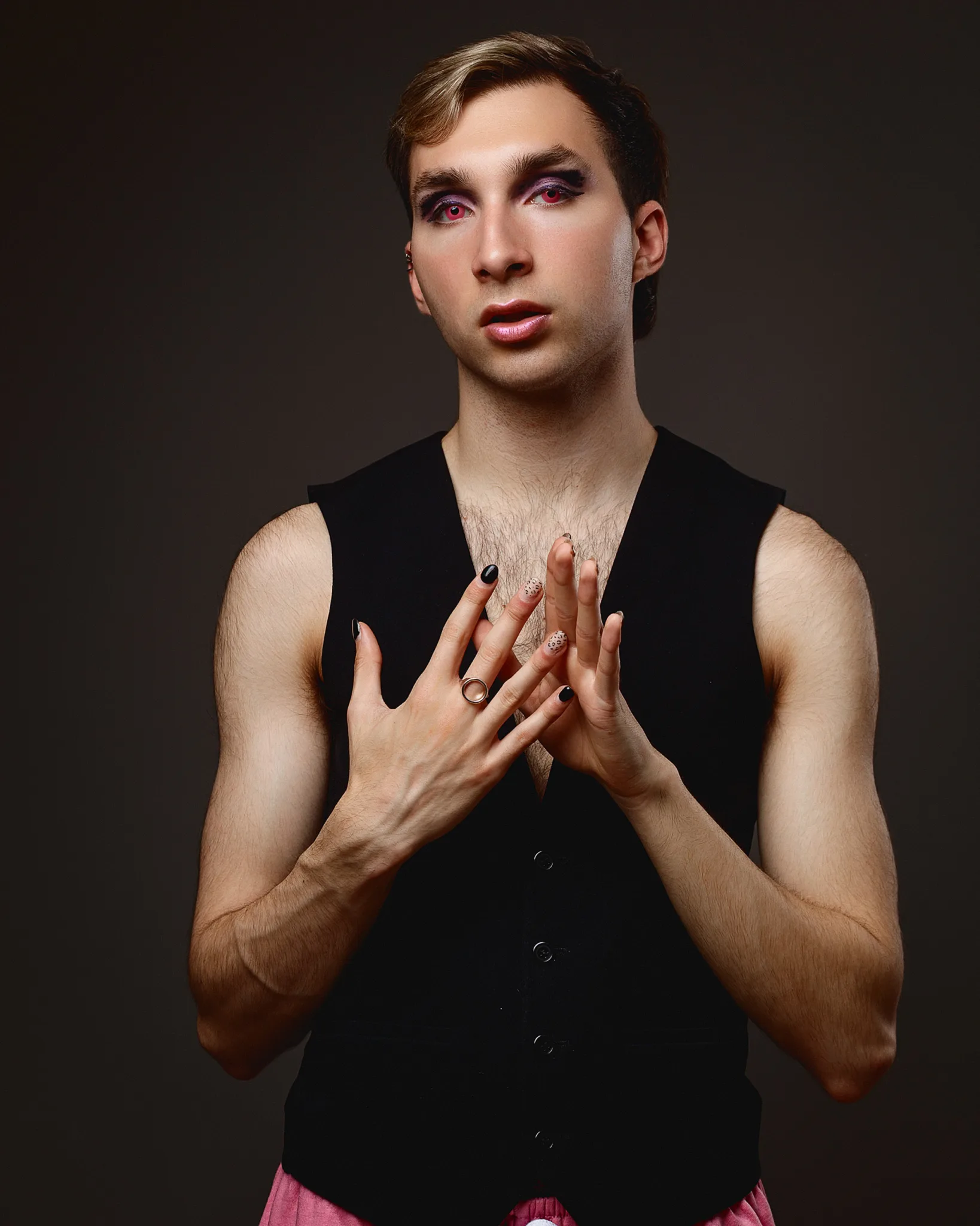Person in black vest with bold makeup