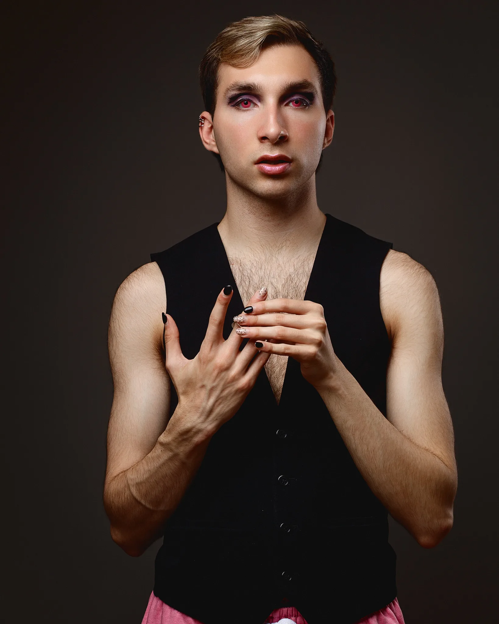 Person with makeup and nail polish posing