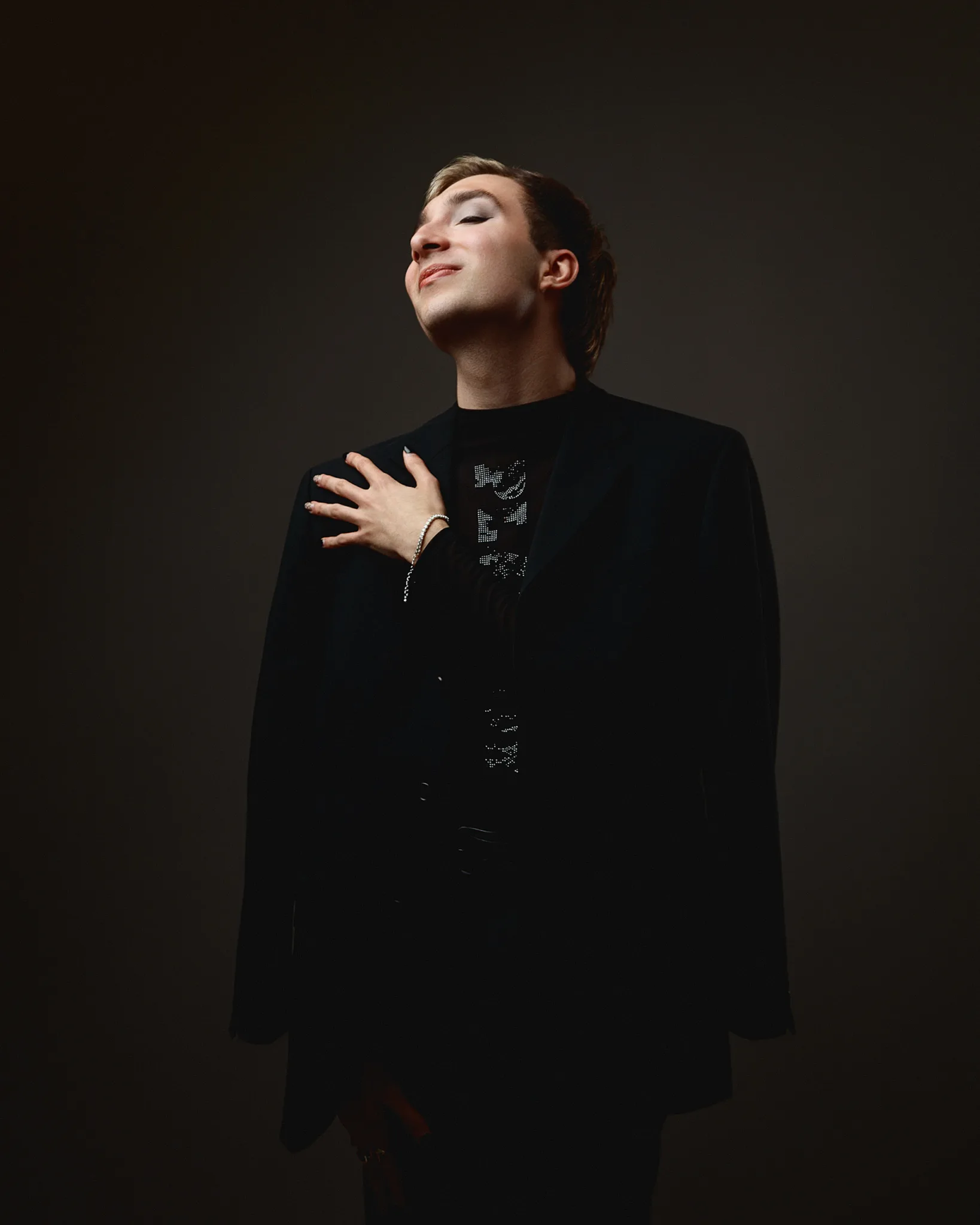 Person posing confidently in dark clothing
