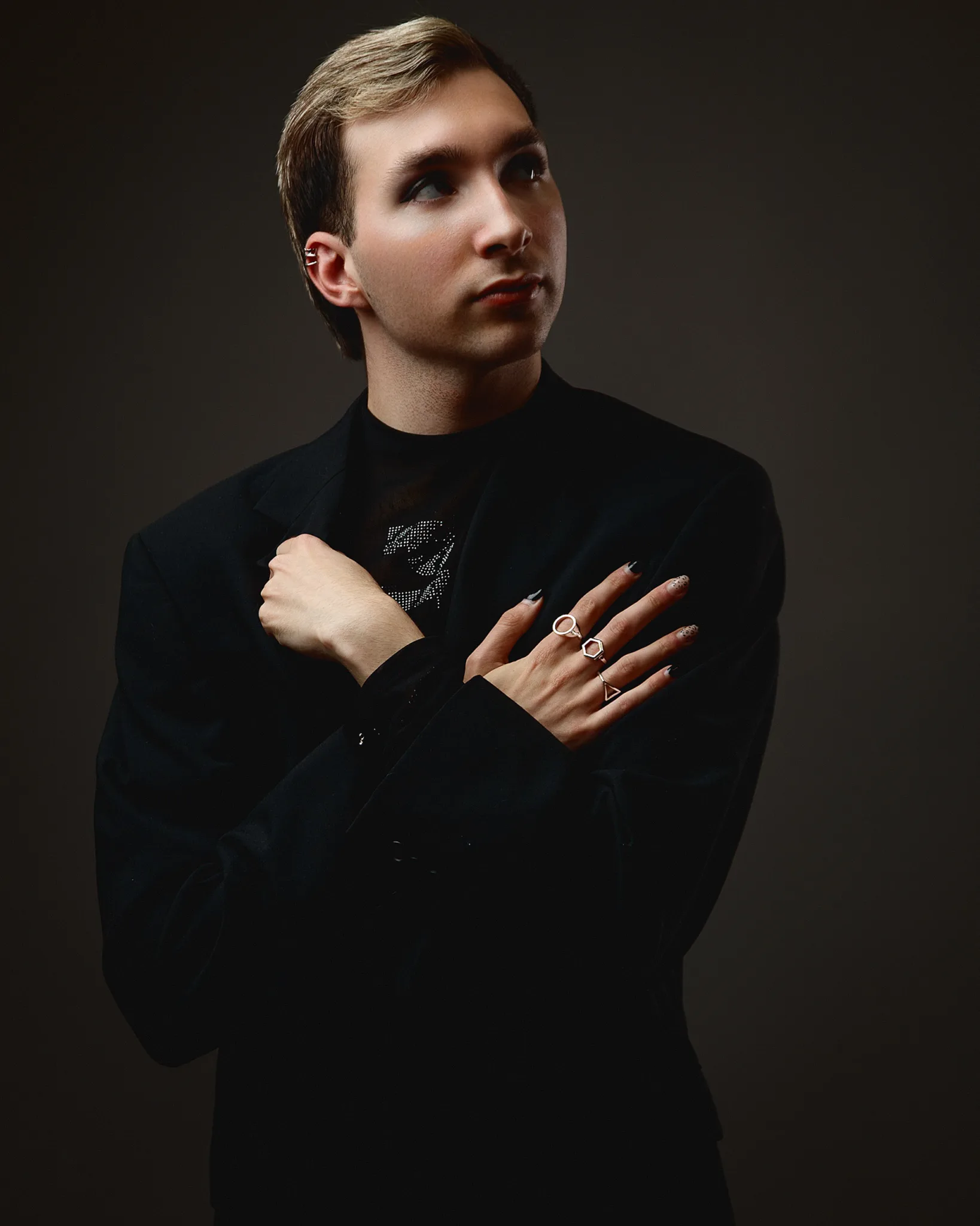 Person in black suit posing confidently