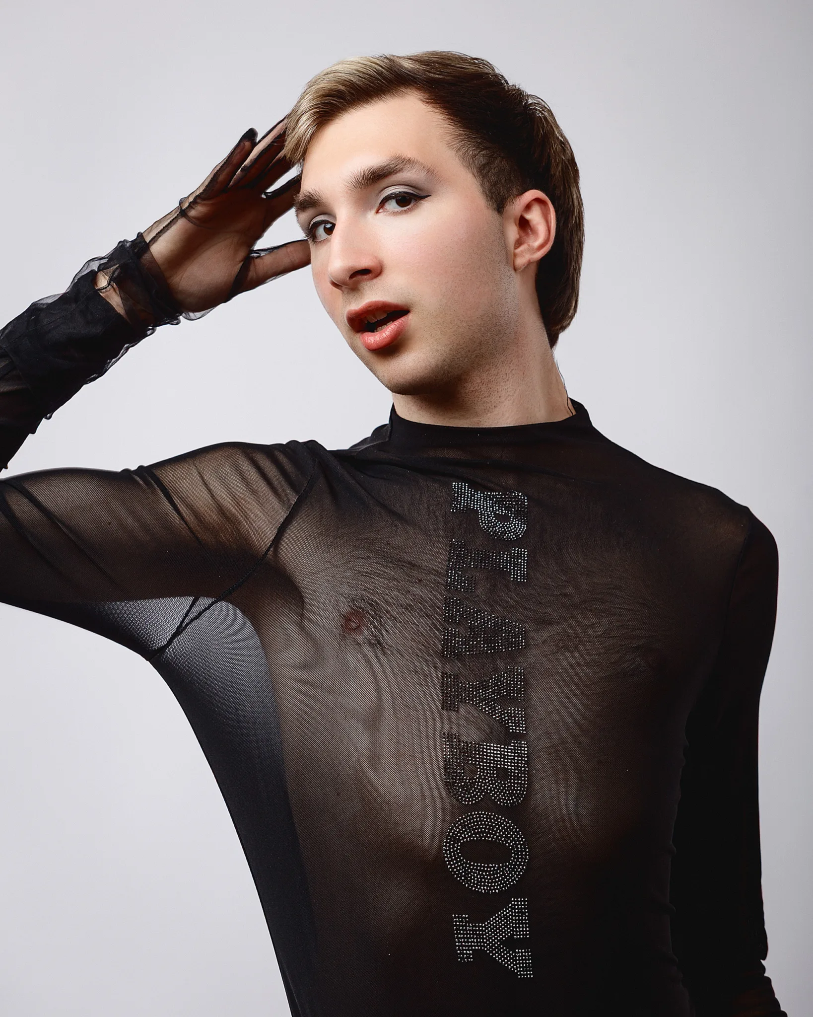 Person posing in a sheer black top