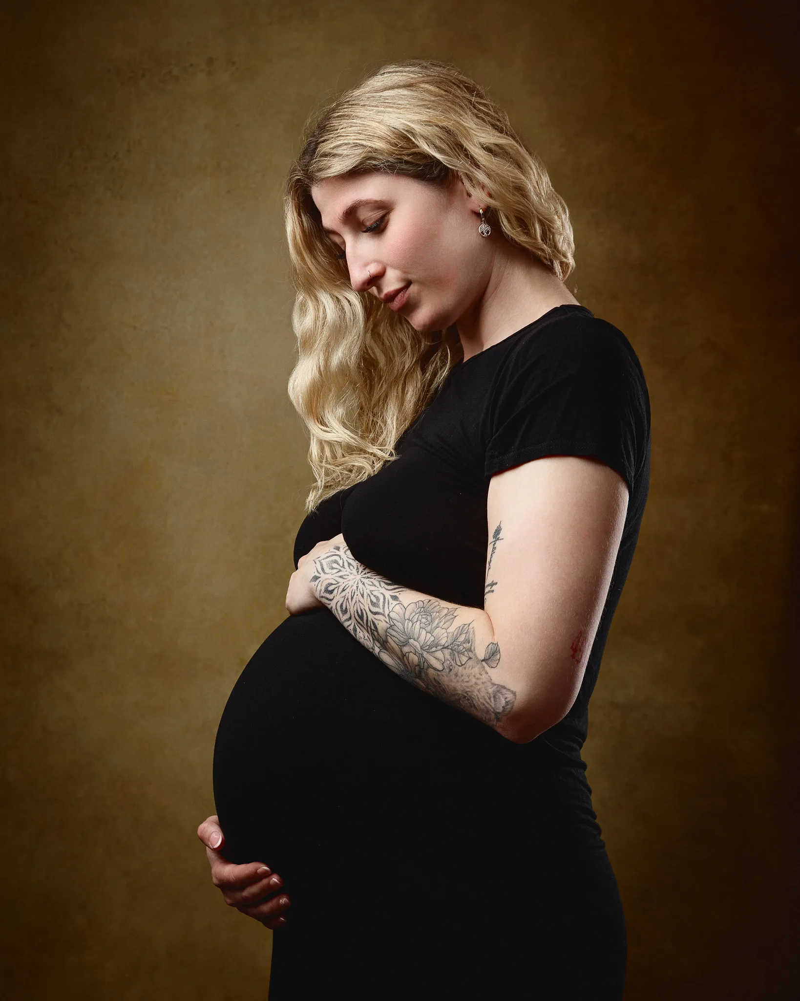 Pregnant woman in black dress, studio portrait