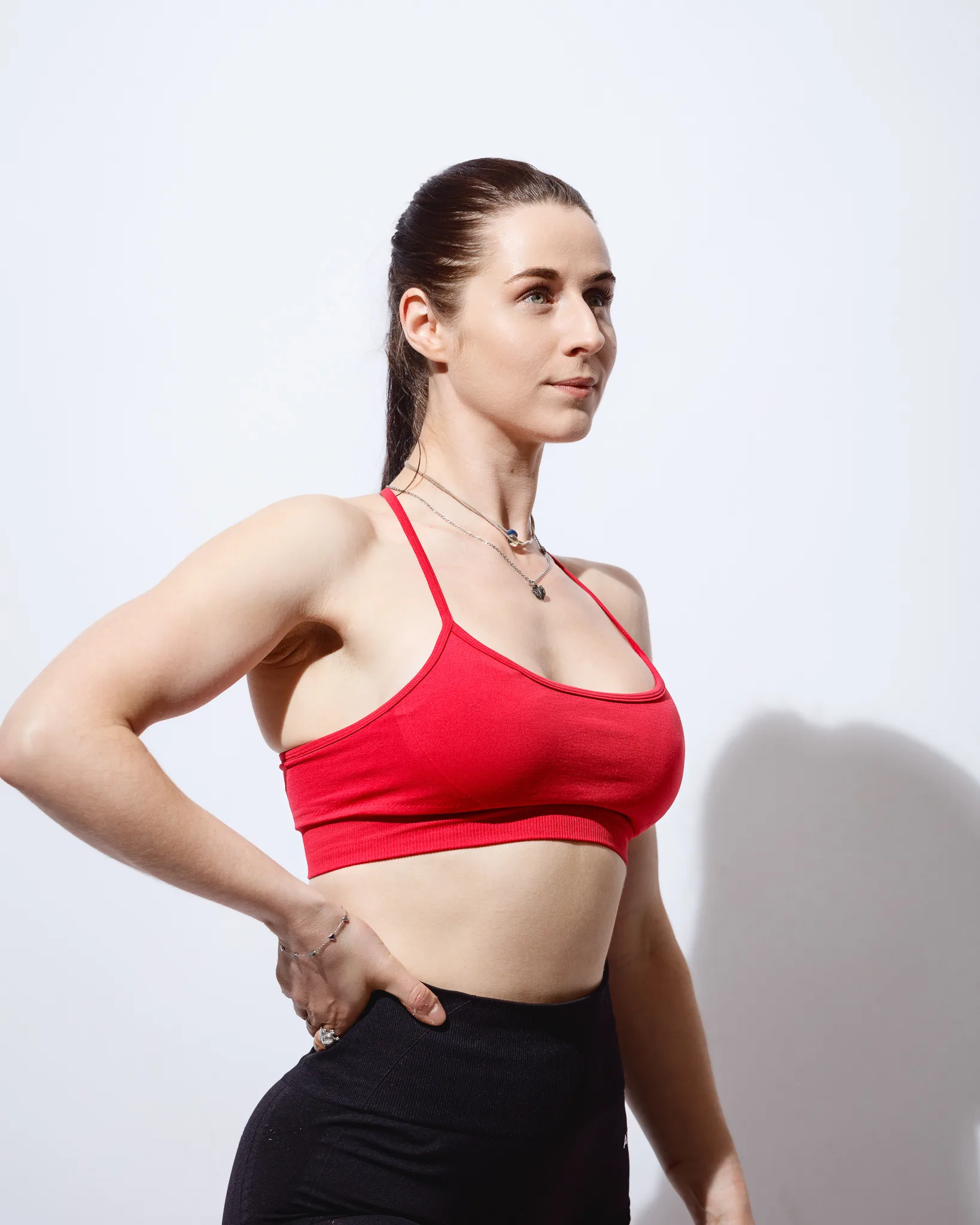 Woman in red sports bra, side profile pose
