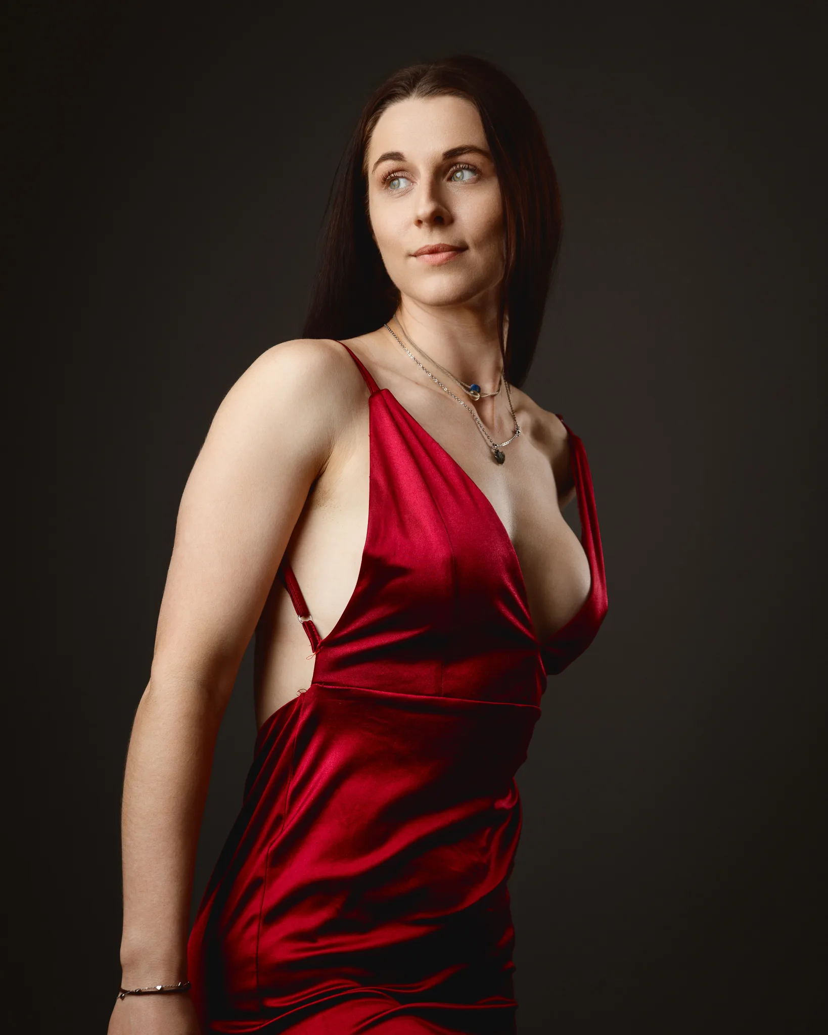 Woman in red satin dress posing in studio
