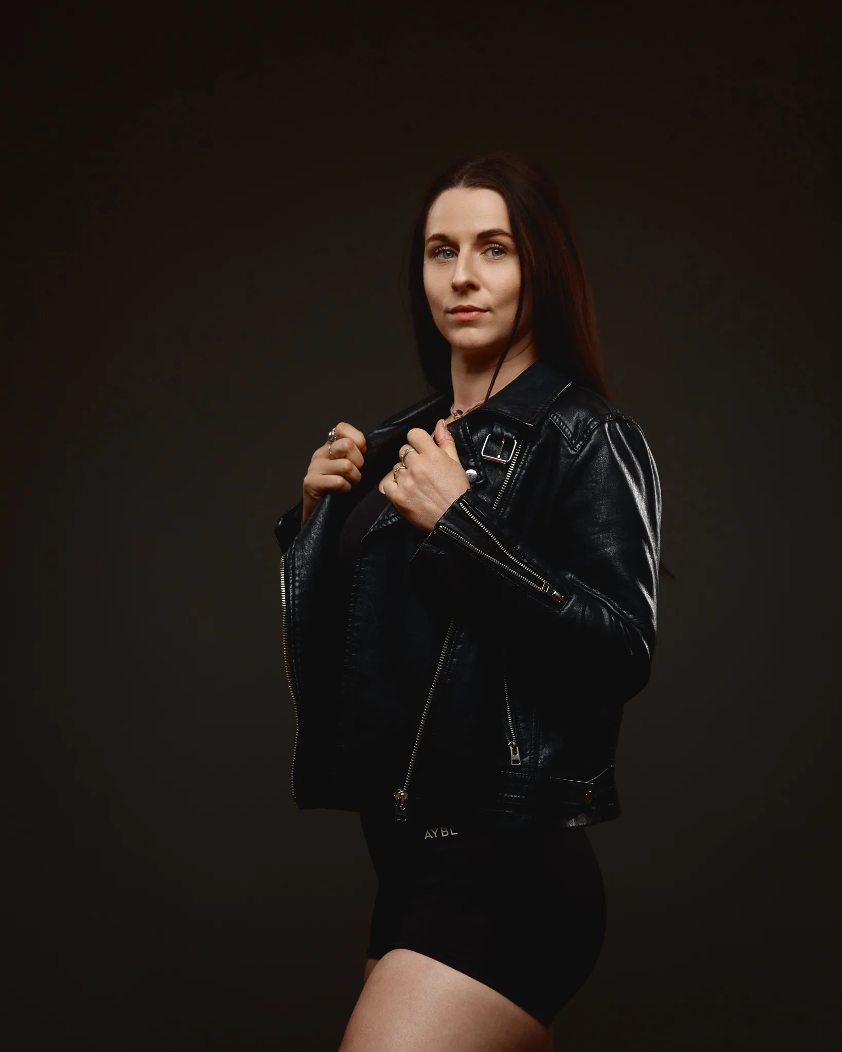 Woman in black leather jacket posing in studio