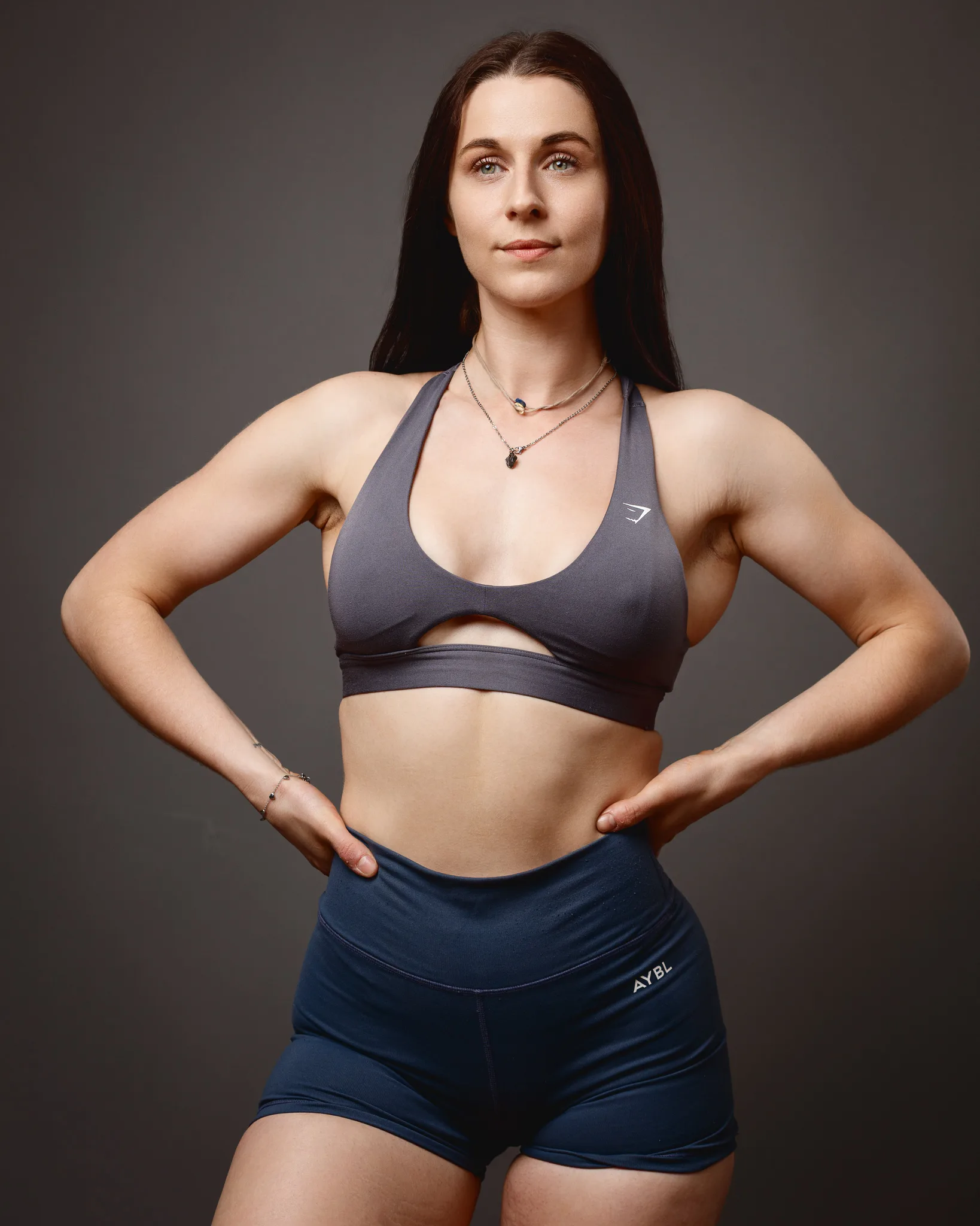 Muscular woman in sportswear posing confidently indoors