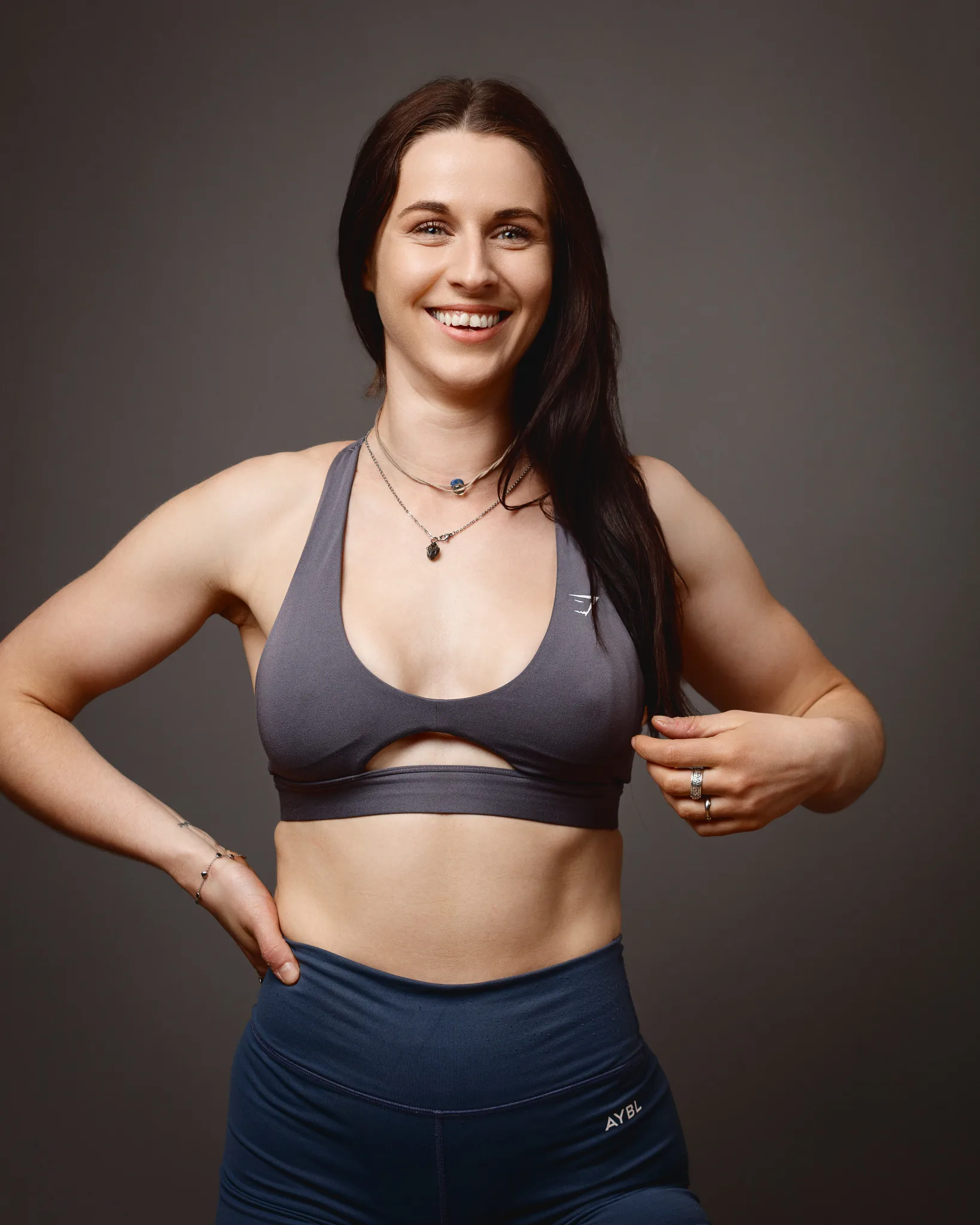 Smiling woman in grey sports bra and leggings