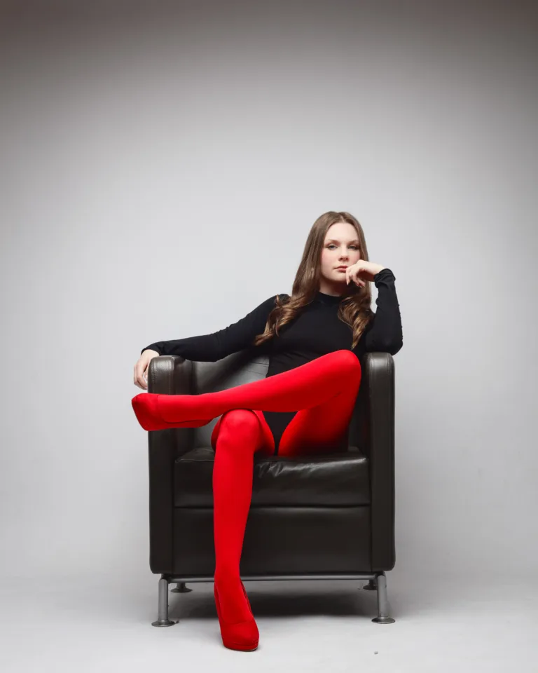 Woman in red tights seated on armchair