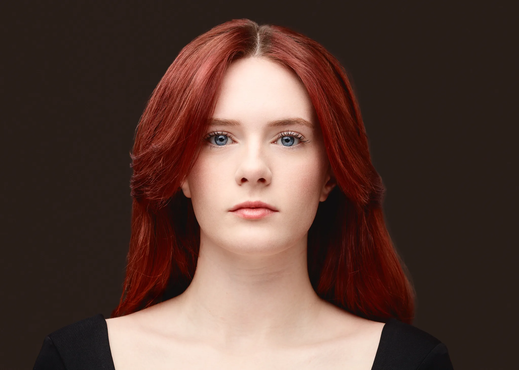 Studio portrait of red-haired woman on dark background