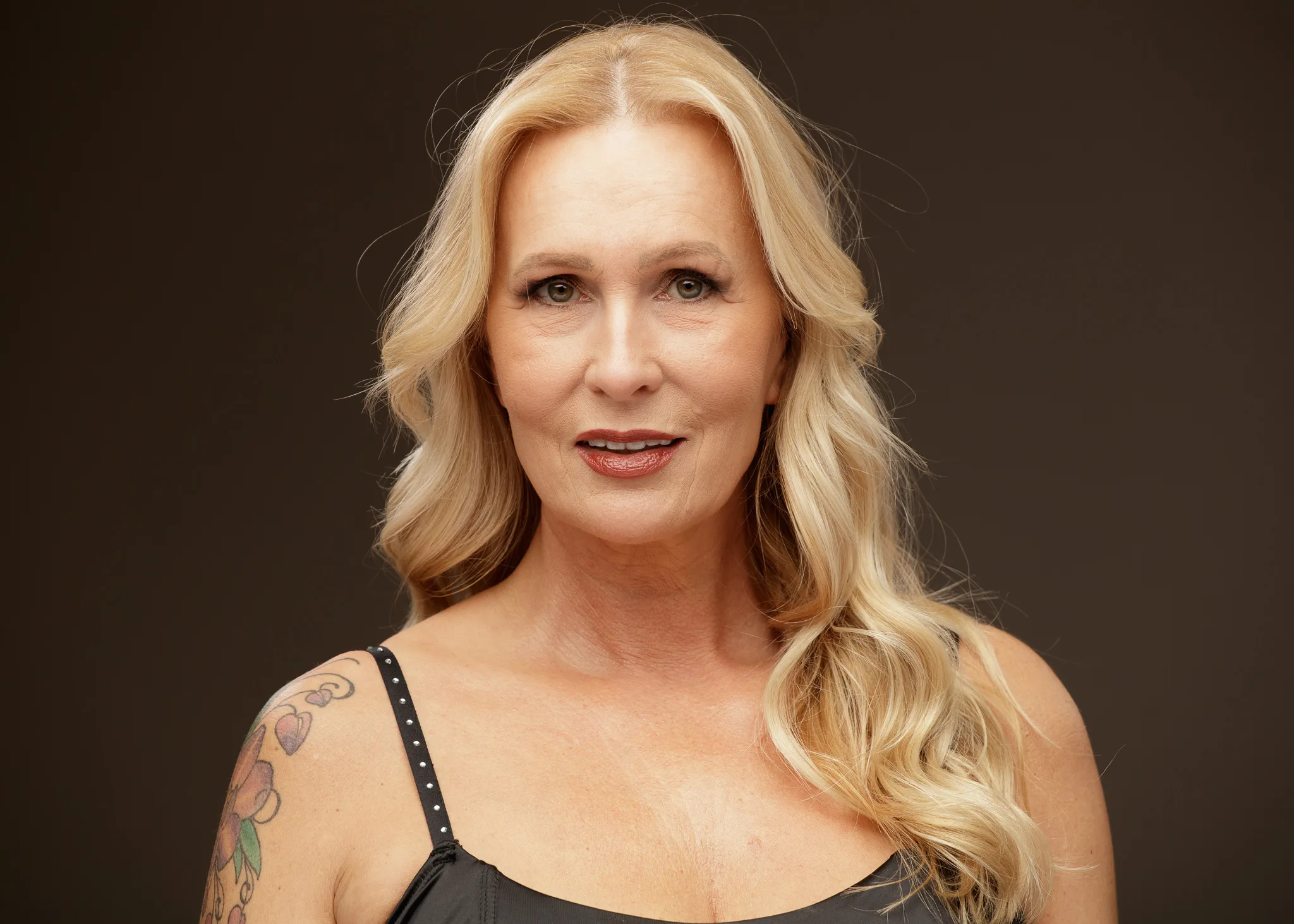 Portrait of blonde woman with tattooed arm
